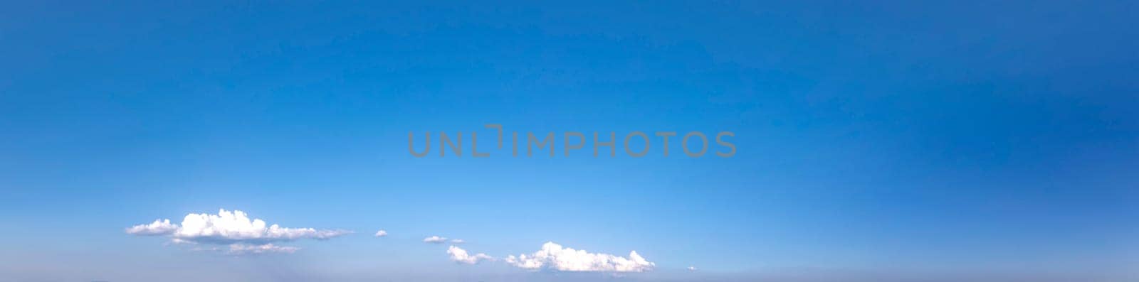 Panoramic view of clear blue sky with some clouds.