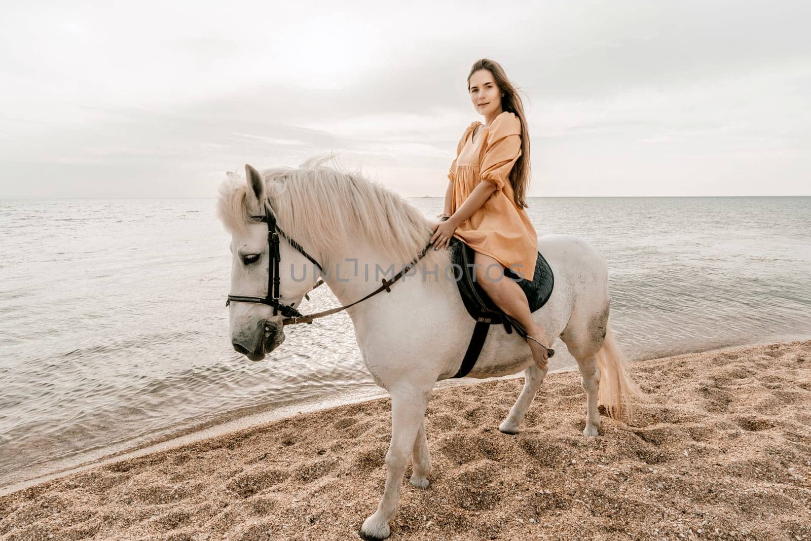 Happy woman and a white horse against the background of the sky and the sea