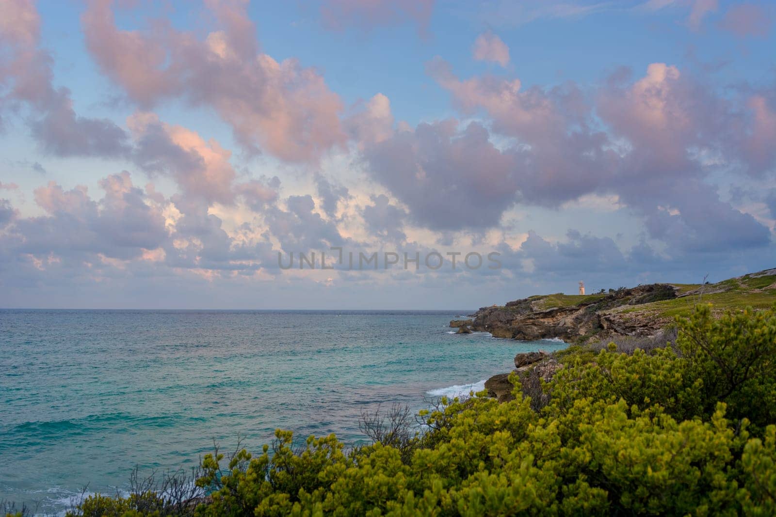 The coastline of the Caribbean Sea with white sand and rocks in Cancun.