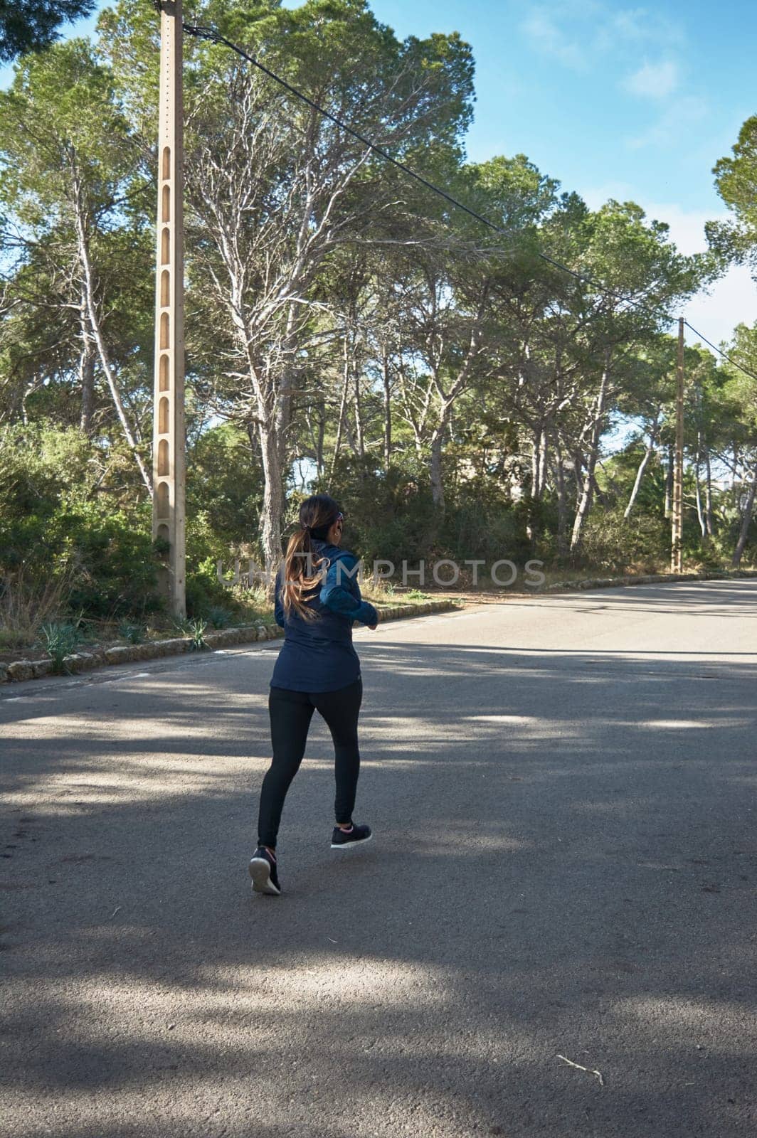 Latin woman, middle-aged, wearing sportswear, training, doing physical exercises, plank, sit-ups, climber's step, burning calories, keeping fit, outdoors by the sea, wearing headphones, smart watch