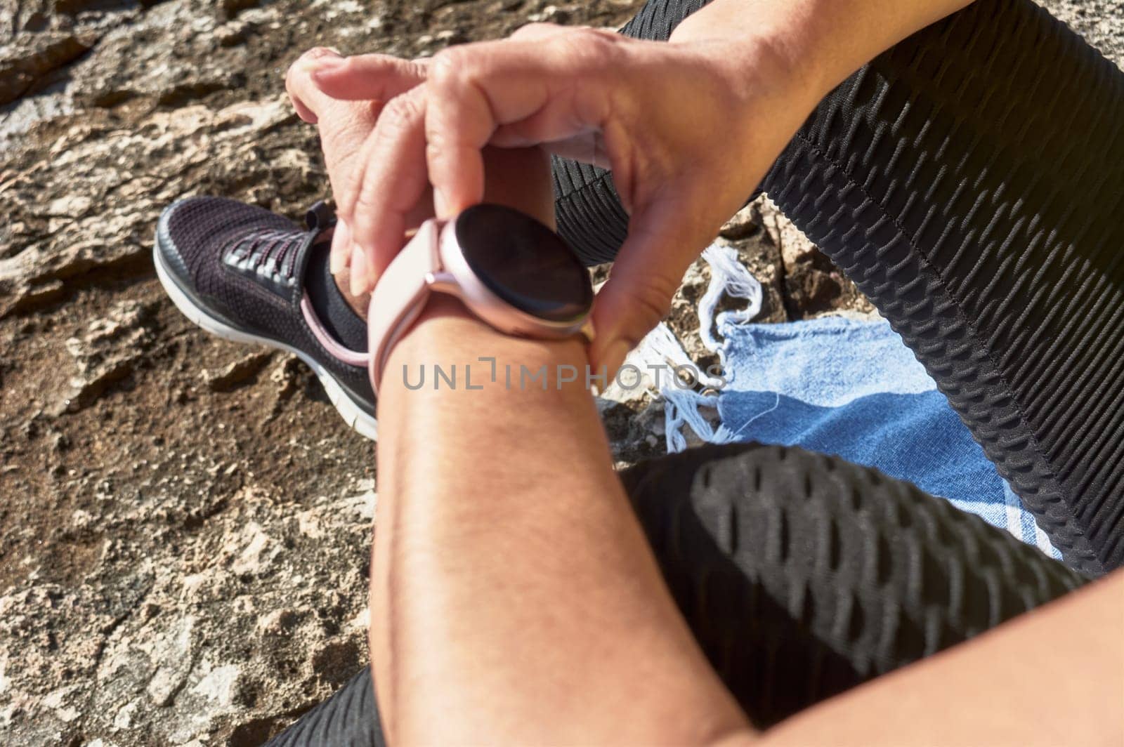 FITNESS WOMAN IN SPORTS SET TRAINING WITH ELASTIC BAND, WEIGHTS, GYM EXERCISES, IN FRONT OF THE WATER.