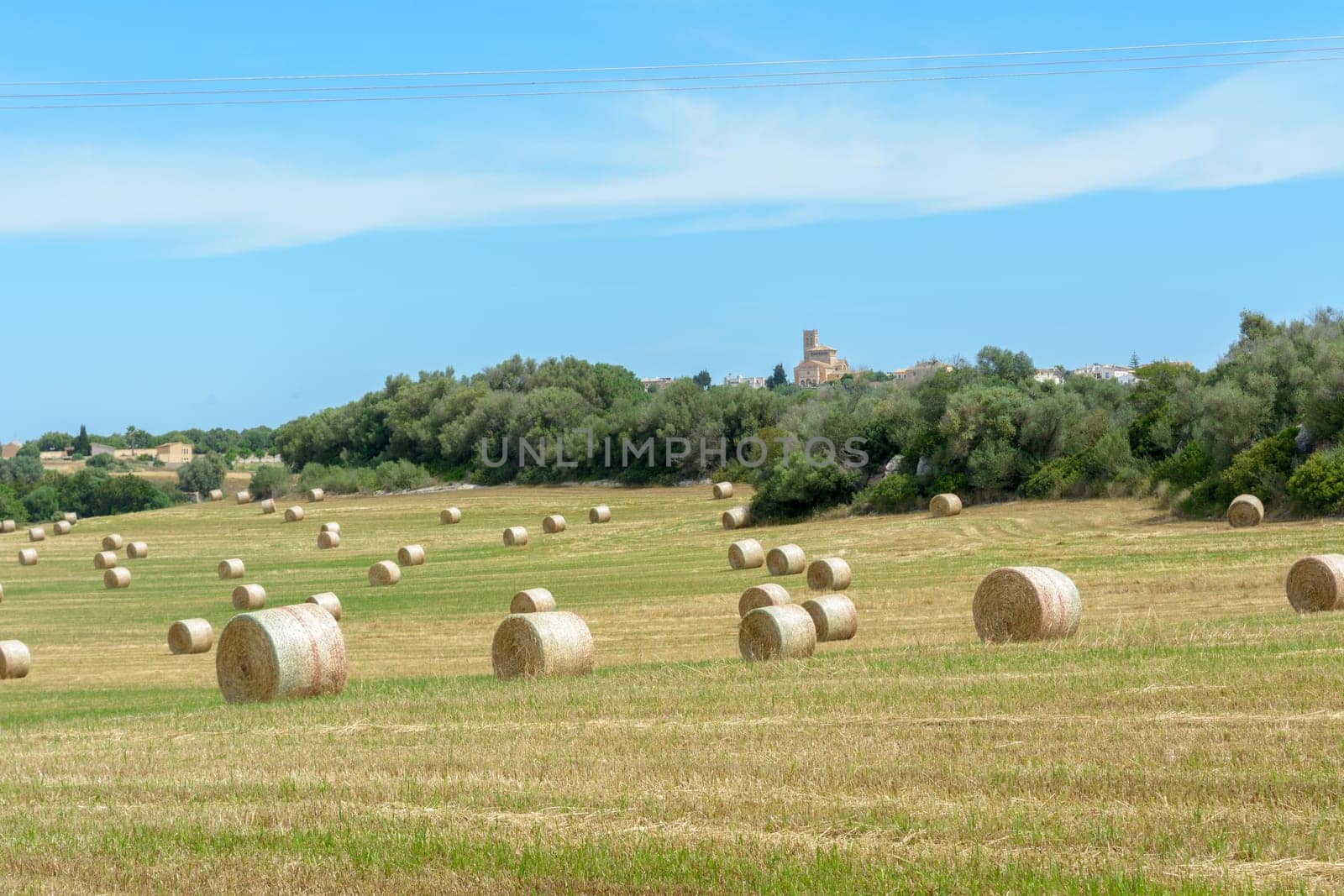 Stacks of straw - bales of hay, rolled into stacks left after harvesting of wheat ears, agricultural farm field with gathered crops rural. Balearic Islands, Majorca, Spain,