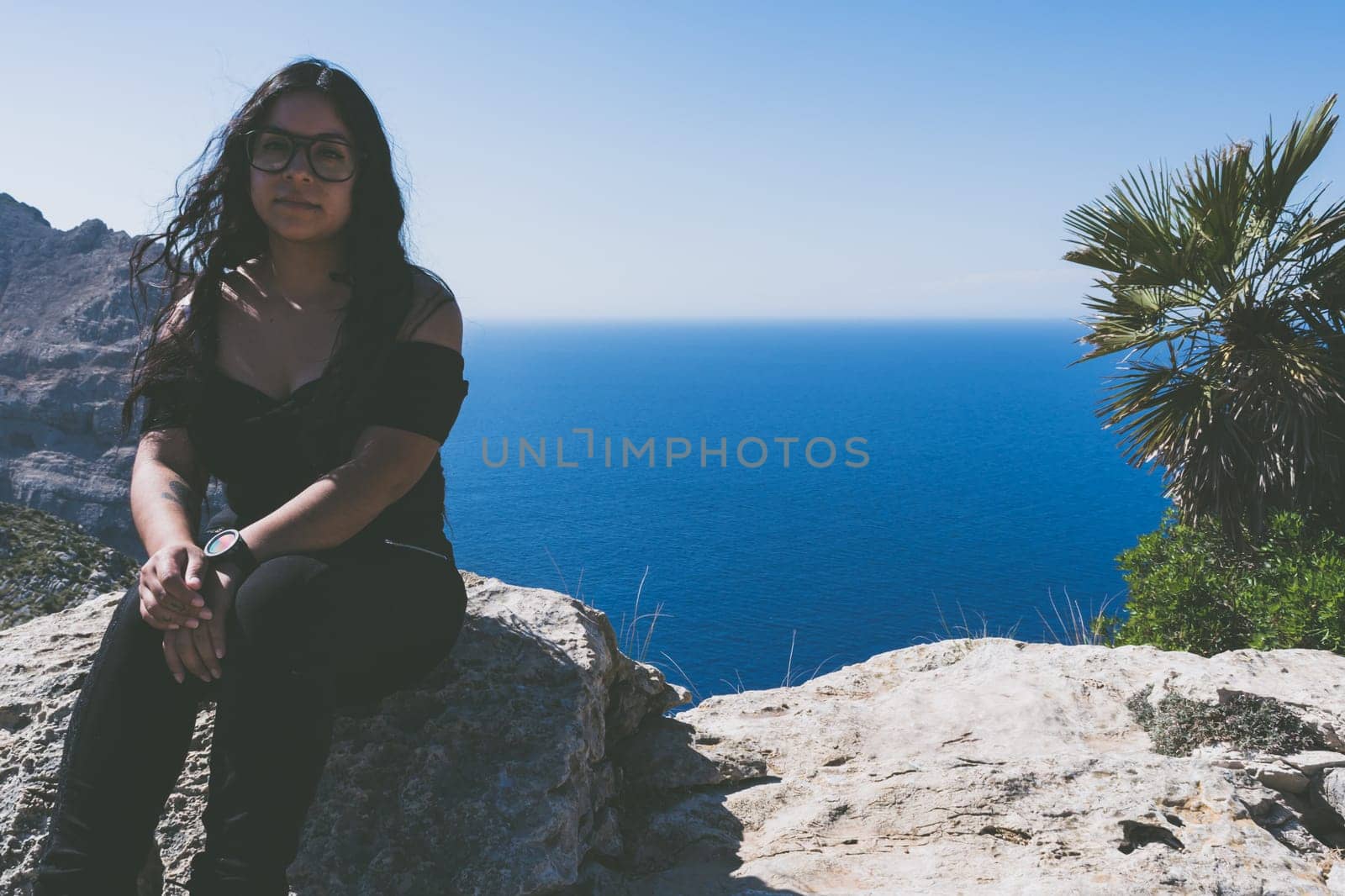 beautiful portrait of a young latin woman dressed in black in front of the sea