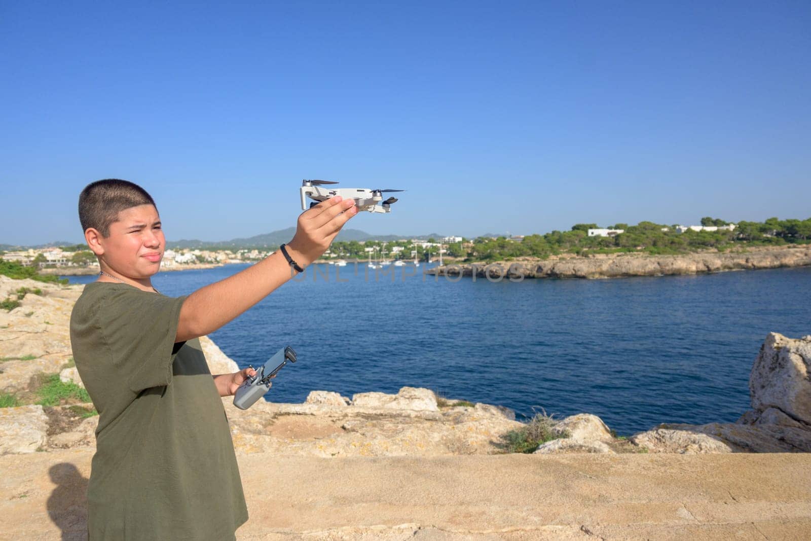 happy teenage boy, preparing and finalizing flight details for drone flight, technology concept Spain, Balearic Islands