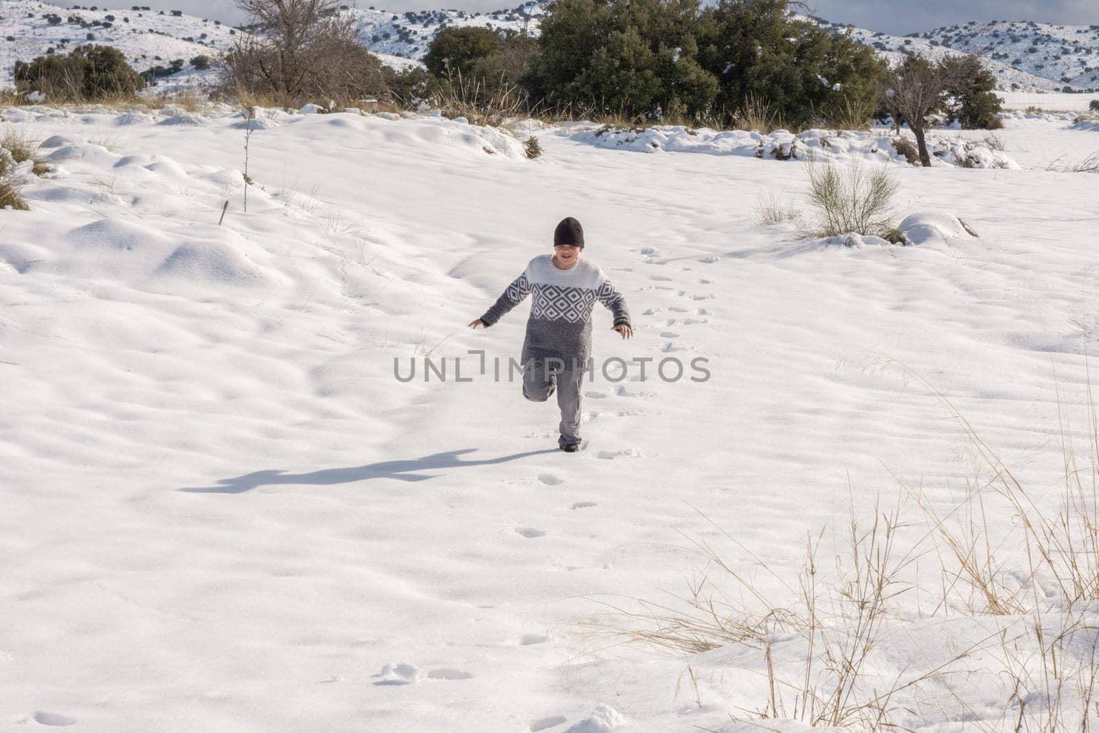 child running and enjoying the snowy landscape,