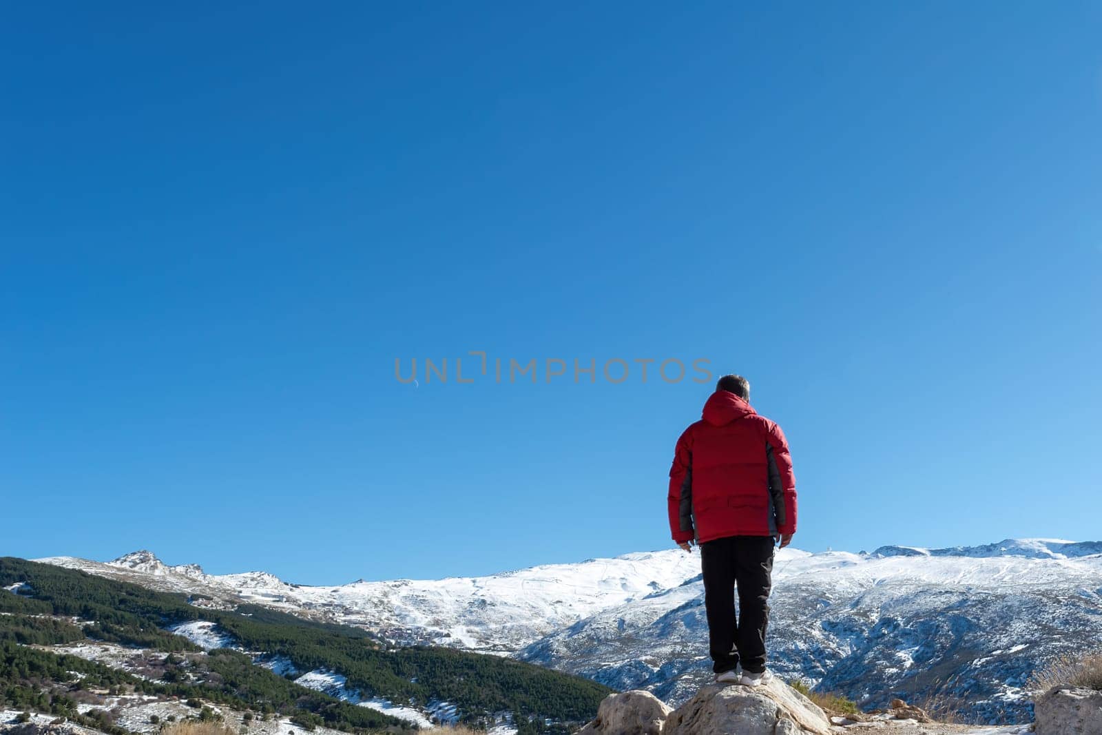 Man standing on the edge of a cliff and contemplating nature's creation in sierra nevada,