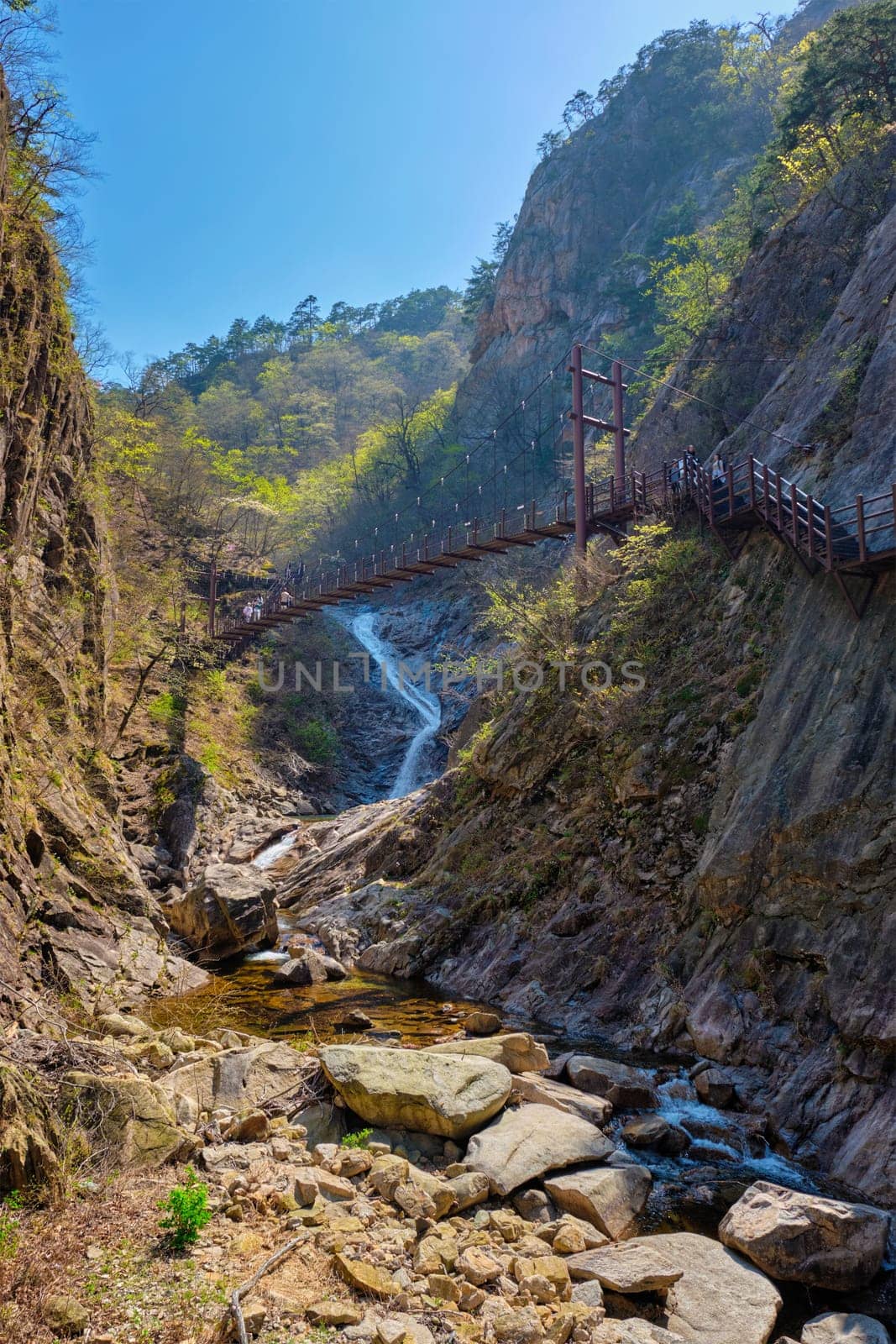 Footbridge on hiking trail with hikers toursits at Biryong Falls Waterfall in Seoraksan National Park, South Korea