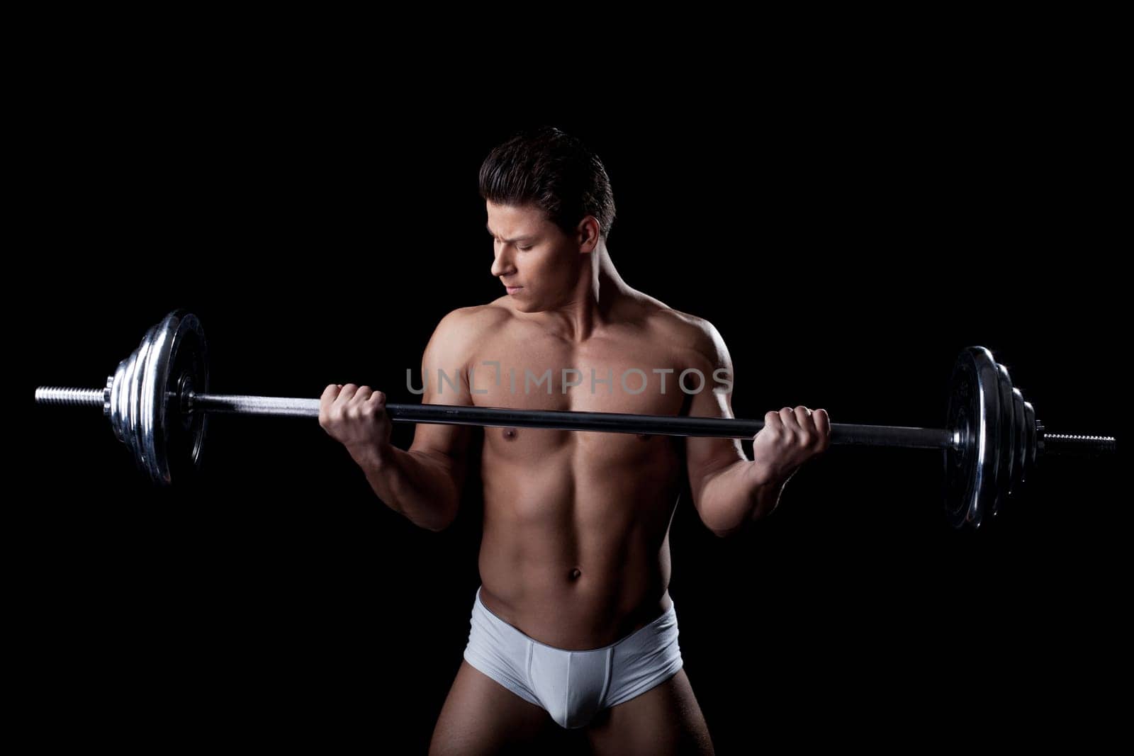 Portrait of handsome sportsman lifting weights, close-up