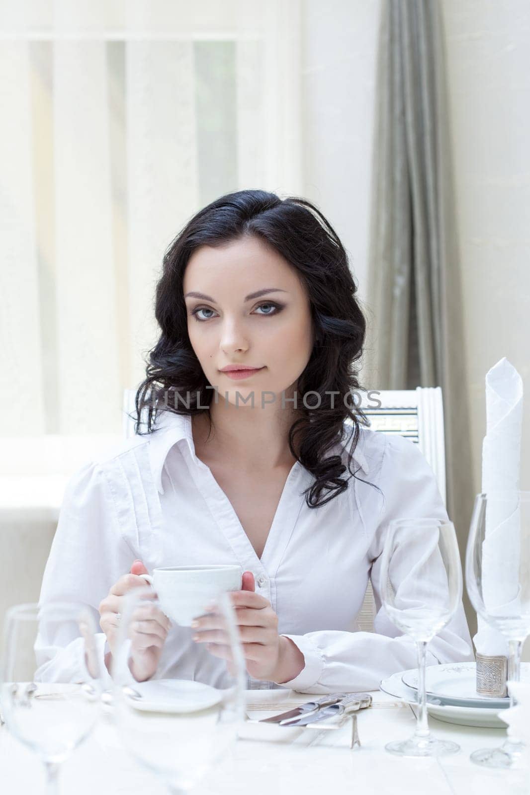 Portrait of attractive brunette sitting at table, close-up