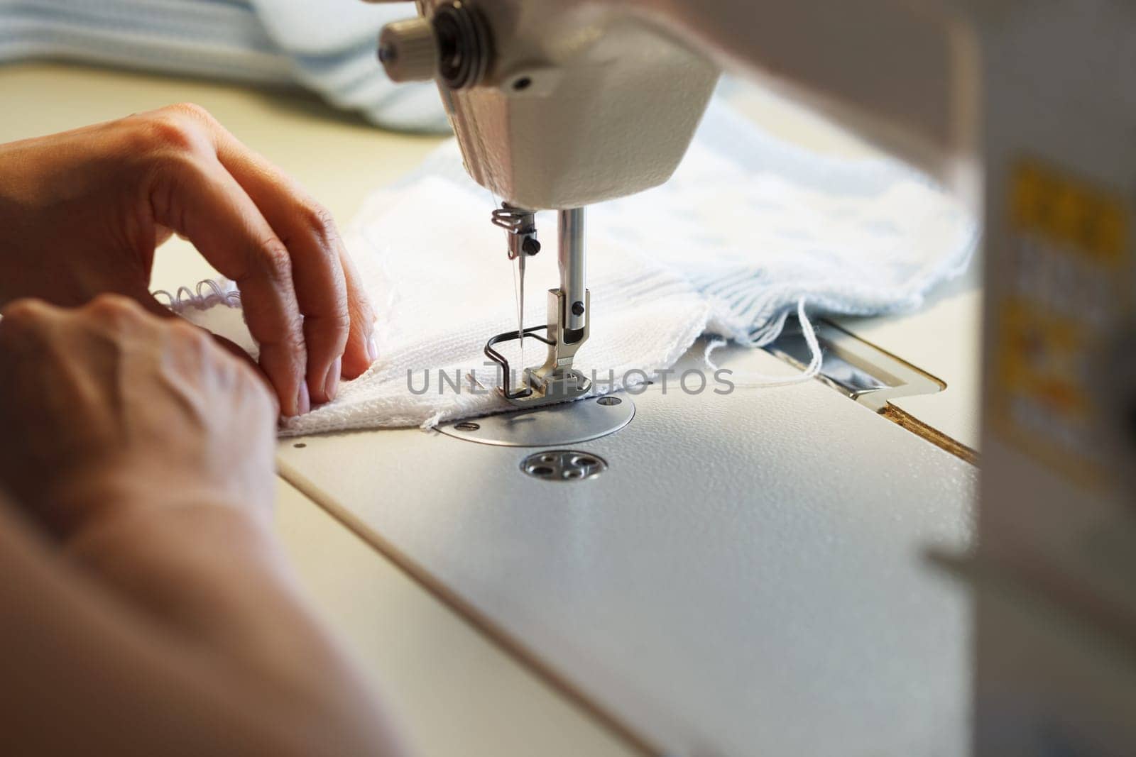 Image of seamstress working on sewing machine, close-up