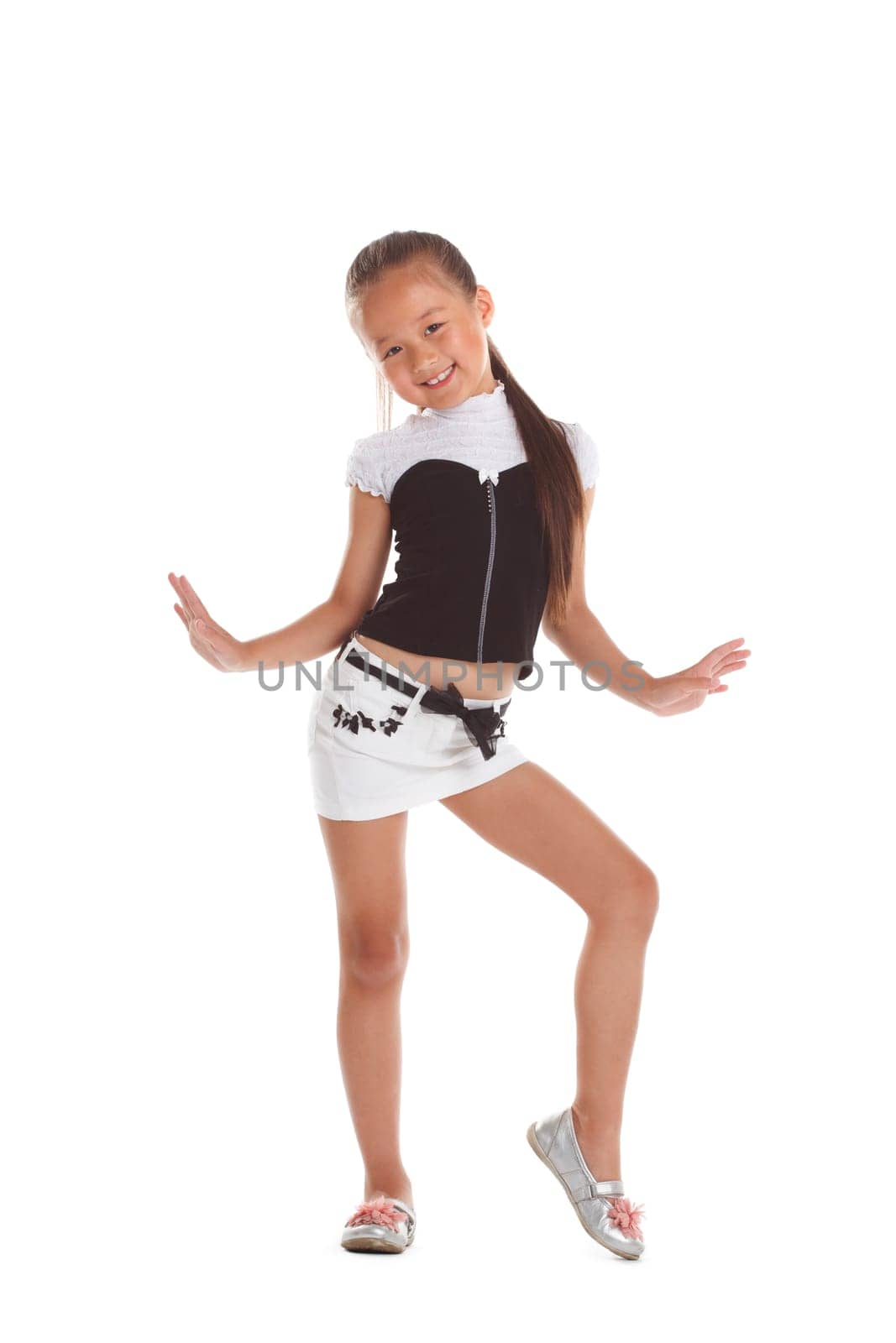 Cheerful little girl posing in fashionable costume, isolated on white