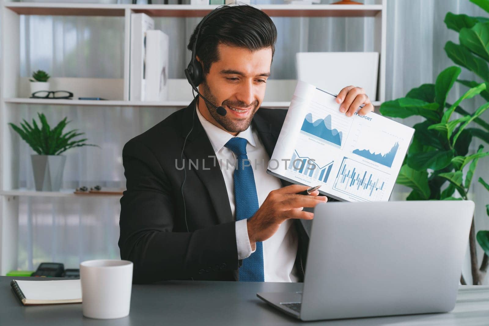 Business man wearing headphone present financial data or BI paper via laptop during online meeting. Remote work concept with virtual meeting presentation of effectiveness remote work. Fervent