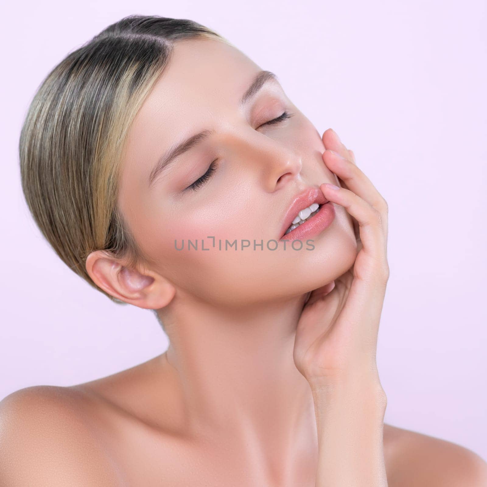 Alluring beautiful woman with perfect smooth and clean skin portrait in isolated background. Beauty hand gesture with expressive facial expression for skincare treatment product or spa.