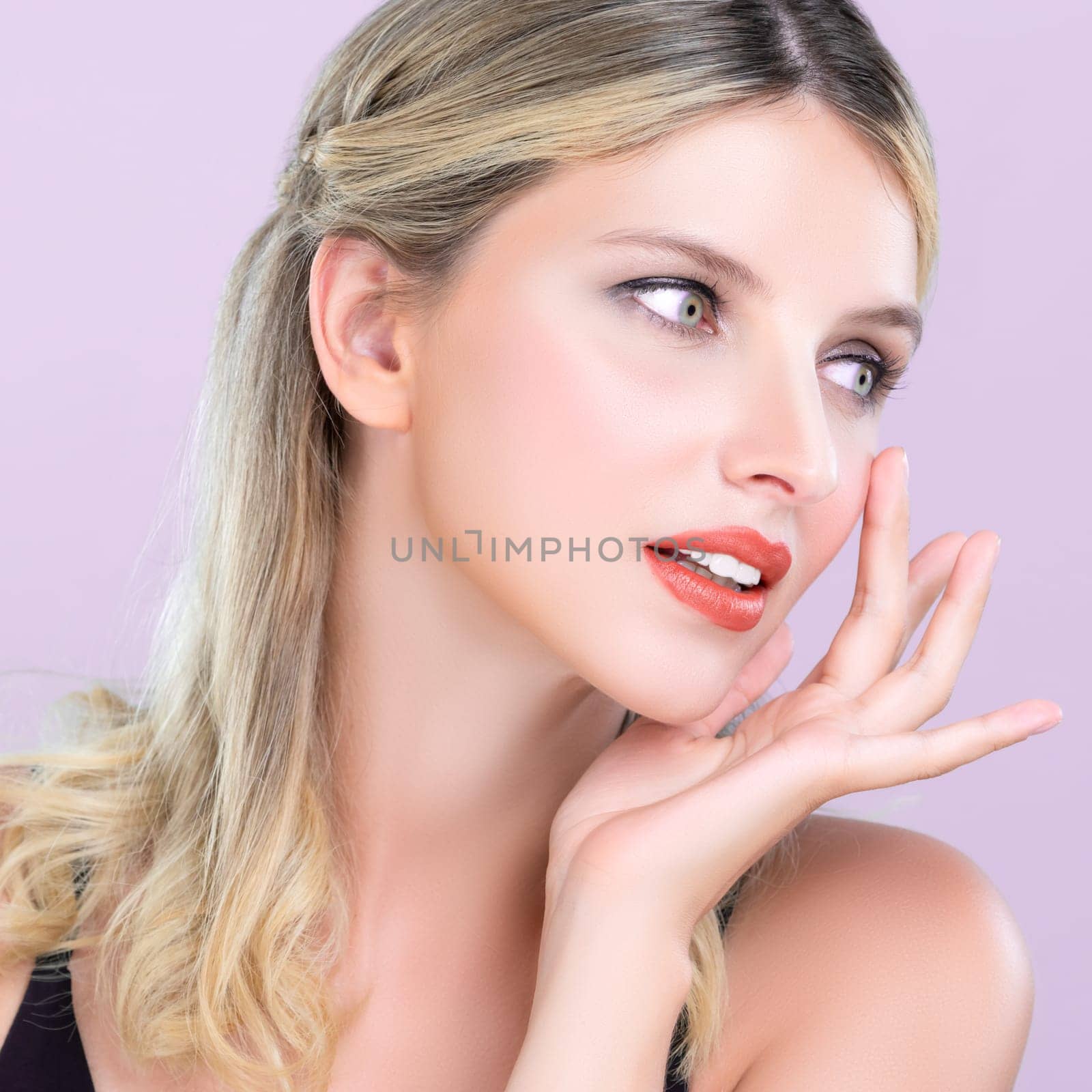 Closeup pretty beautiful woman with alluring perfect smooth and clean skin portrait in pink isolated background. Hand gesture with expressive facial expression for beauty model concept.