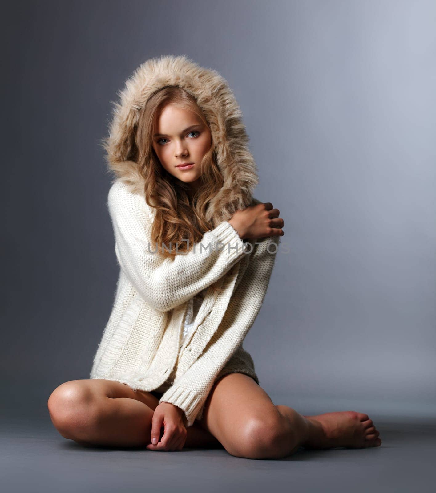 Beautiful girl posing in woolen jacket with hood, close-up