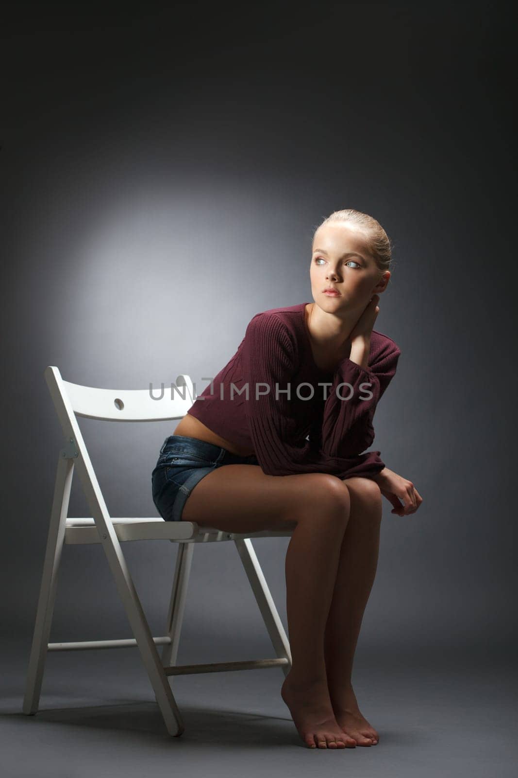 Thoughtful model posing in stylish casual clothes, on gray background