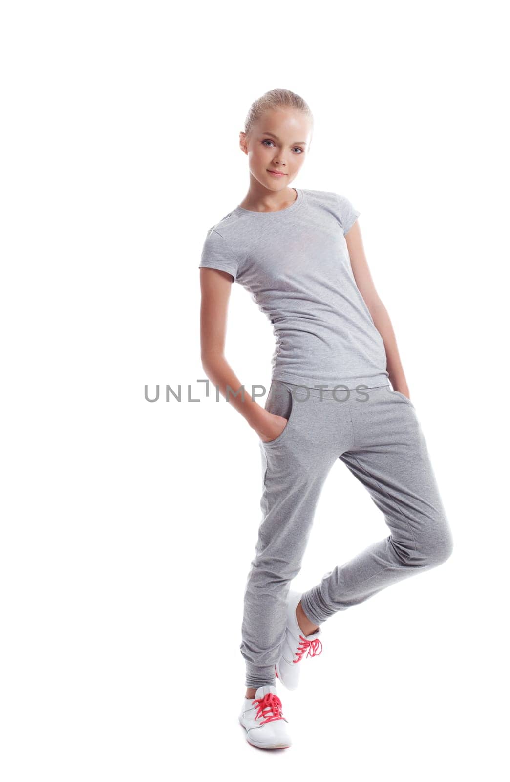 Slender young athlete posing in studio, isolated on white background