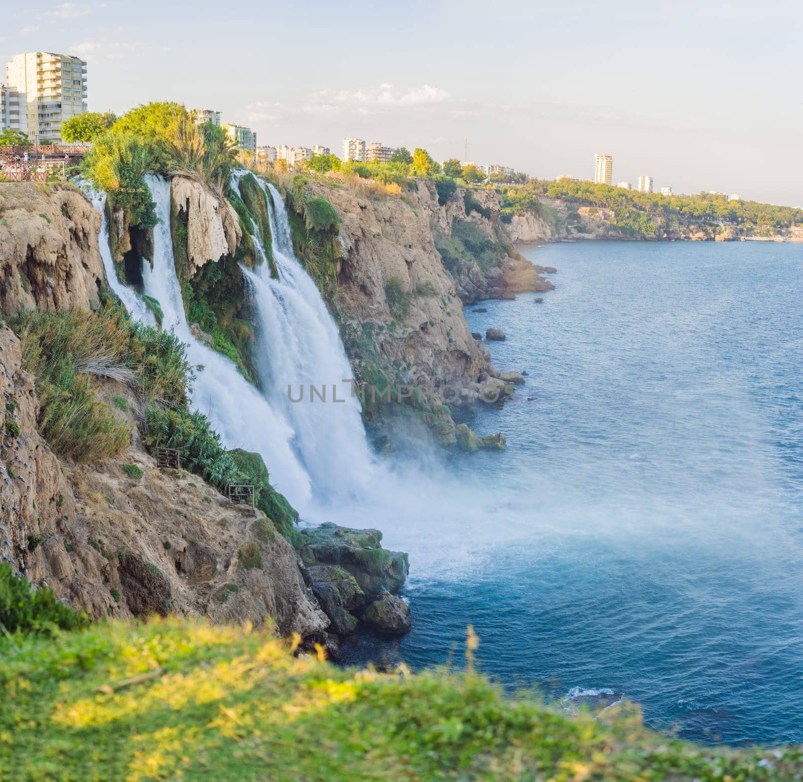 Lower Duden Falls drop off a rocky cliff falling from about 40 m into the Mediterranean Sea in amazing water clouds. Tourism and travel destination photo in Antalya, Turkey. Turkiye. by galitskaya