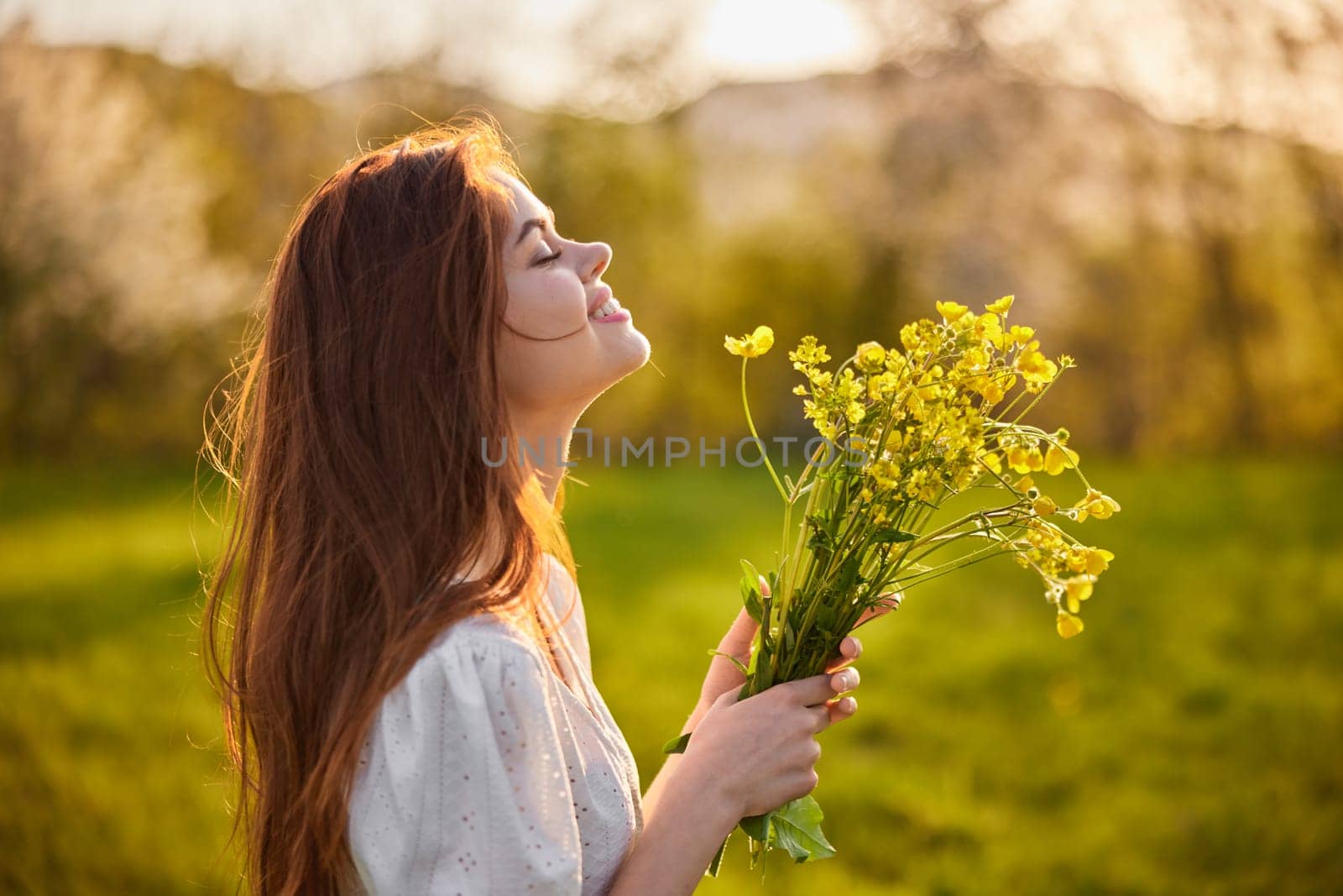 portrait of a woman standing sideways to the camera during sunset with a bouquet of wildflowers. High quality photo