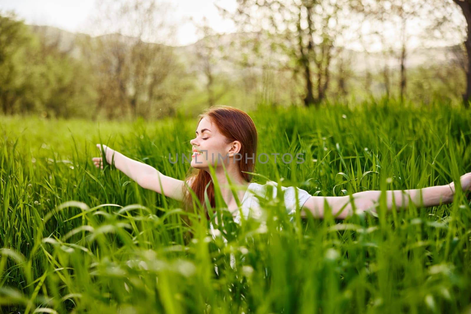 a woman rejoices in a summer day and raises her hands enthusiastically. High quality photo