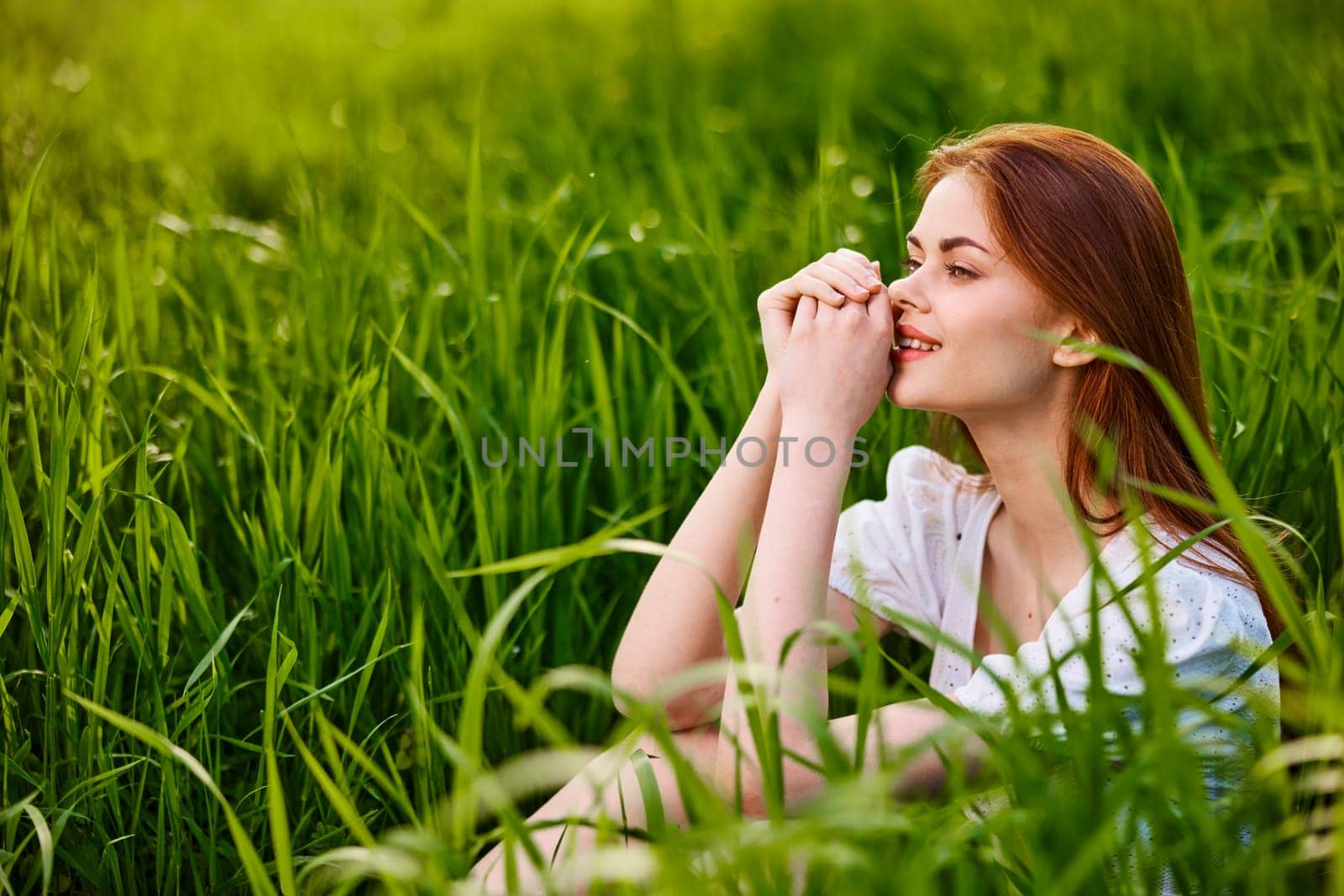 adorable woman sitting in nature resting in tall grass. High quality photo