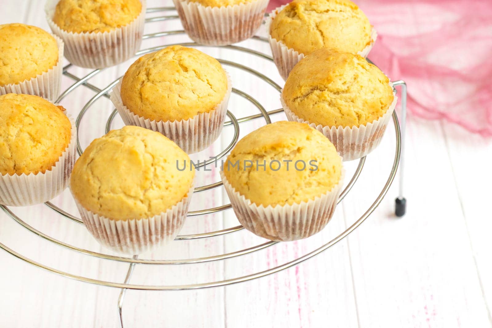 selective focus. fresh muffins cool on a cooling rack. Homemade vanilla cupcakes. Biscuit dessert prepared in the home kitchen. Hot white flour cupcakes. High quality photo