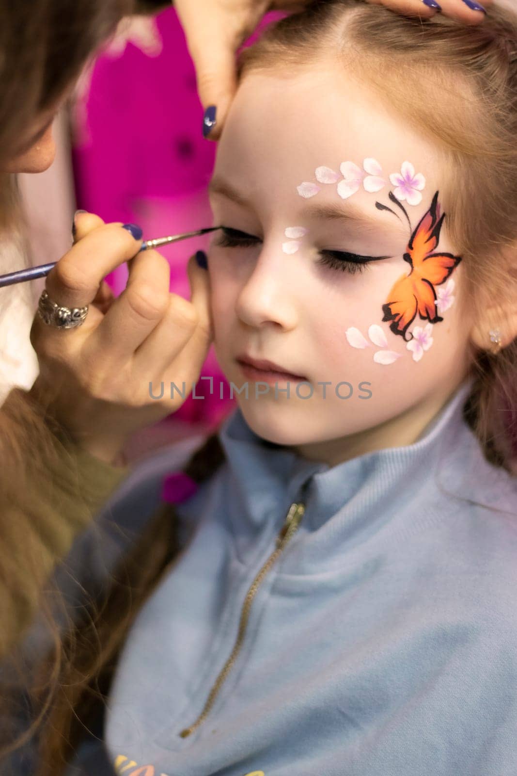 childrens makeup face paint drawings Girls face painting 23.02.2022 . Kyiv, Ukraine. Little girl having face painted on birthday party. High quality photo