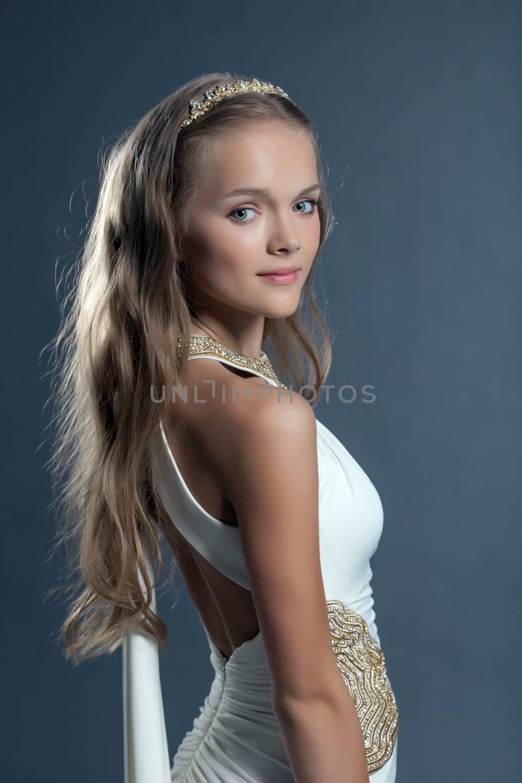 Portrait of curly girl posing in cocktail dress, close-up