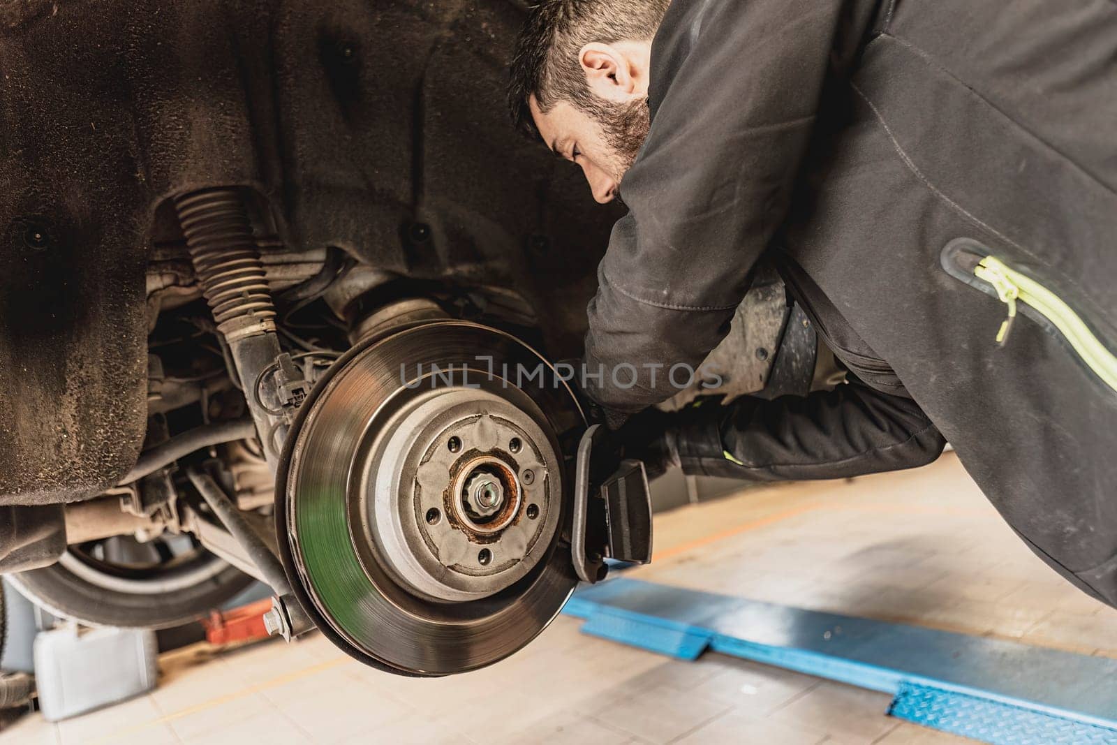 Mechanic Hands Replace Brake Pads on Car by pippocarlot
