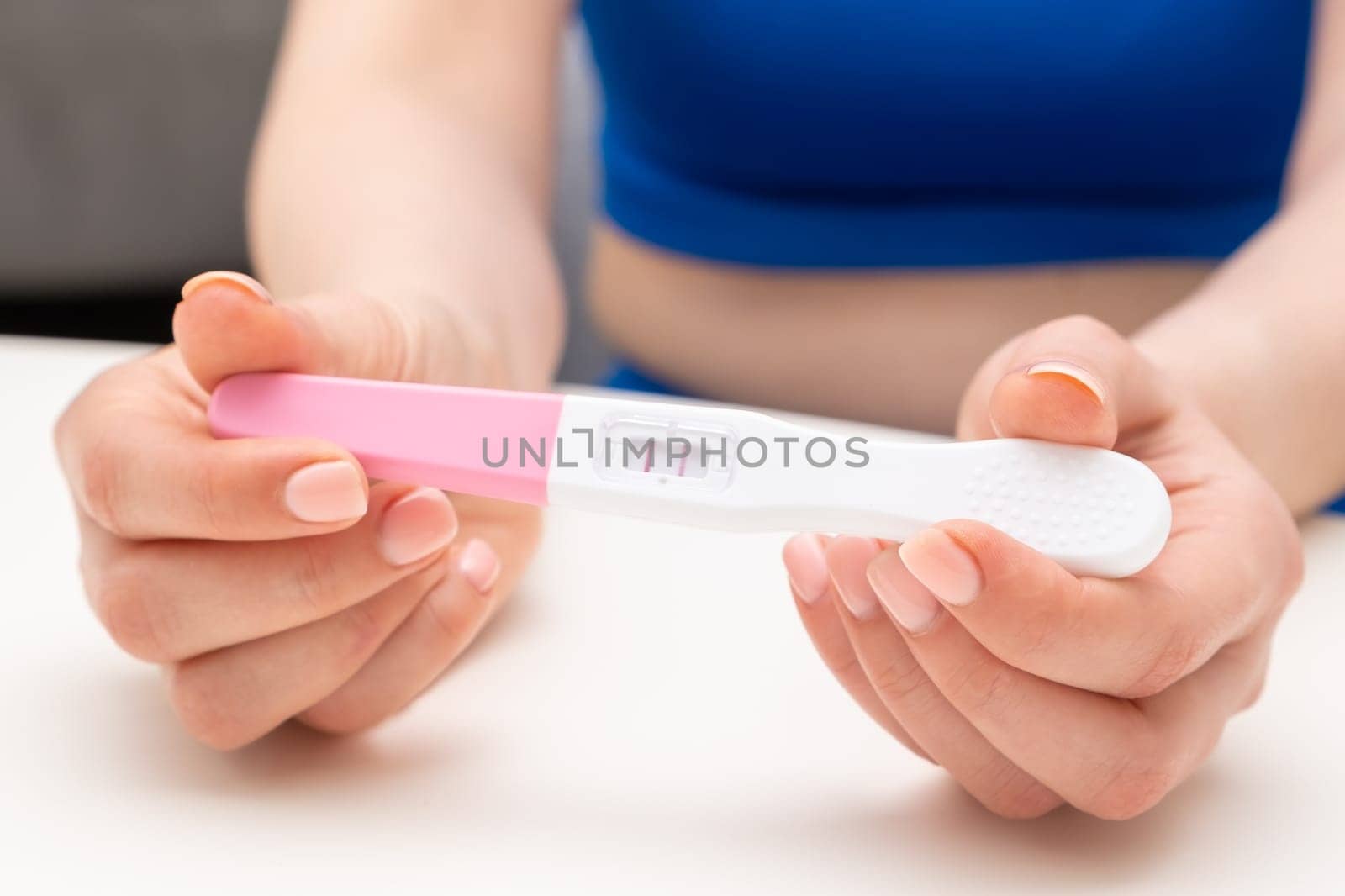 Close up woman holding a positive pregnancy test