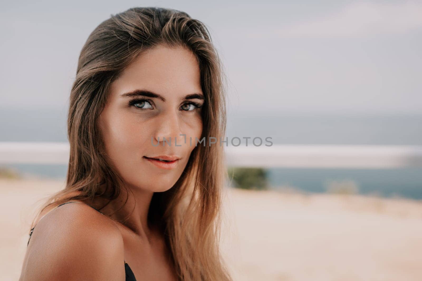 Happy woman portrait in cafe. Boho chic fashion style. Outdoor photo of young happy woman with long hair, sunny weather outdoors sitting in modern cafe. by panophotograph