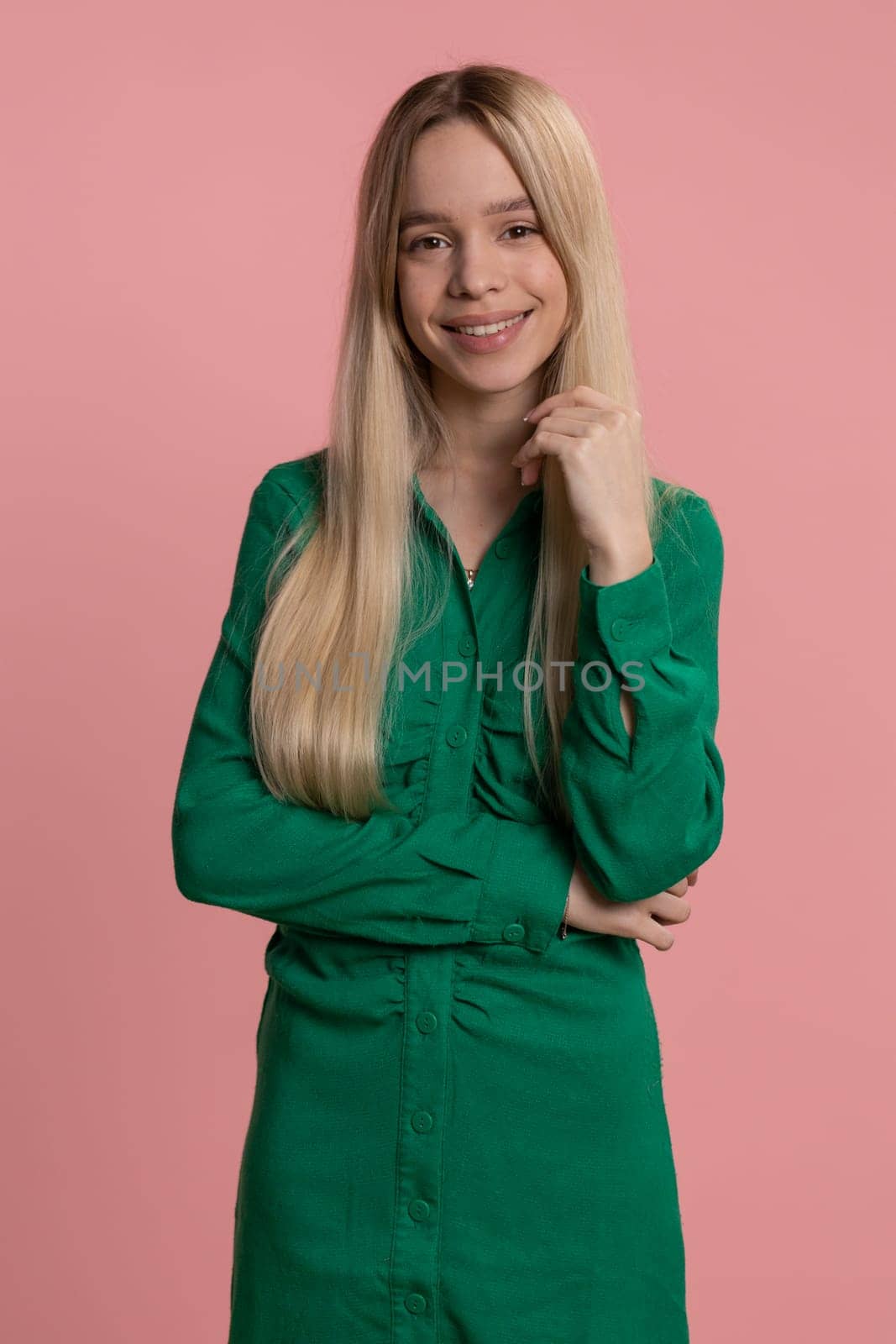 Happy calm caucasian woman smiling friendly, glad expression looking away dreaming resting, relaxation feel satisfied concept good news celebrate win. Girl on studio pink background indoors. Vertical