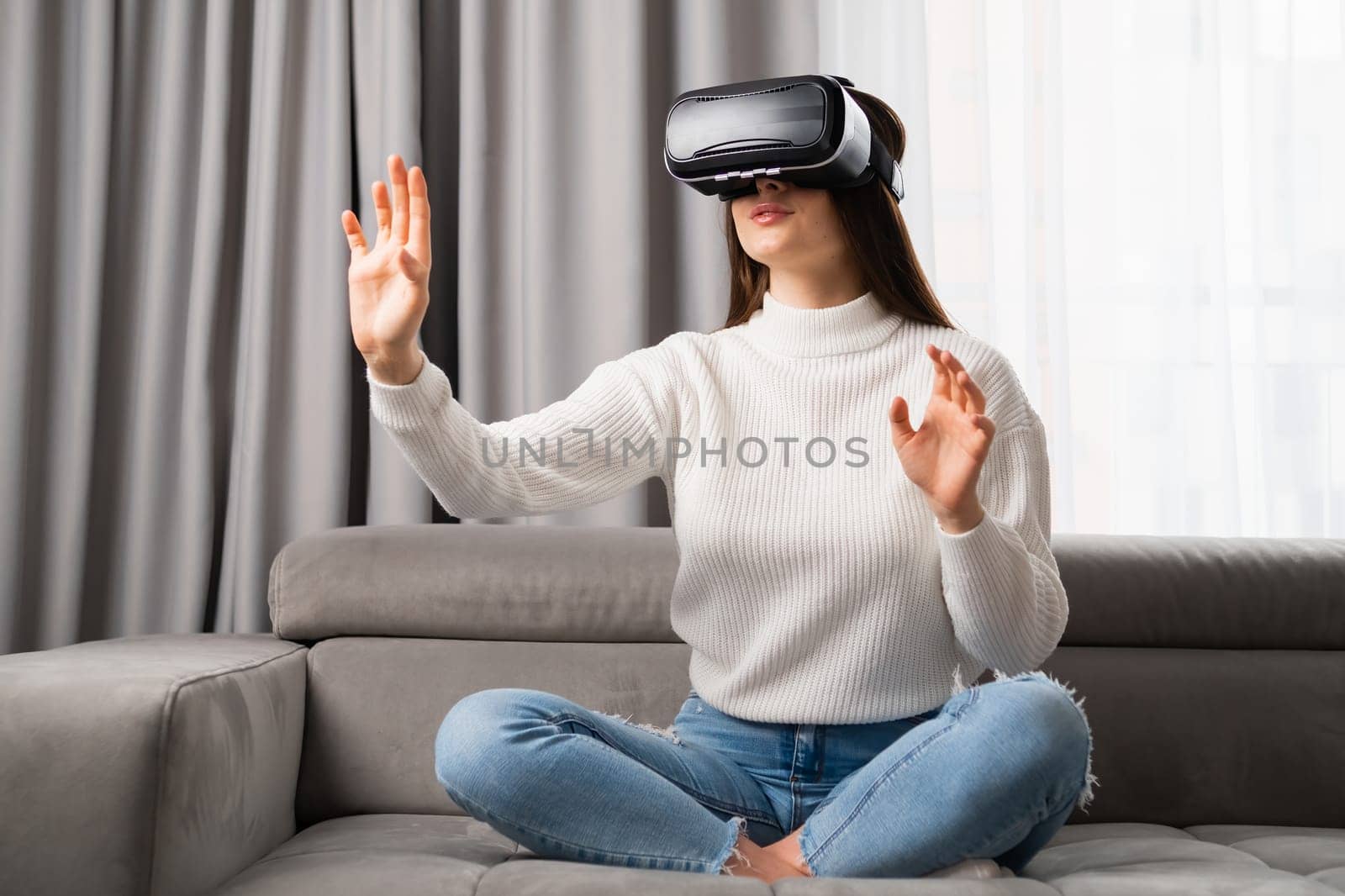 Girl in VR goggles playing games and touching something in the air. Innovative technology for exploring cyber space