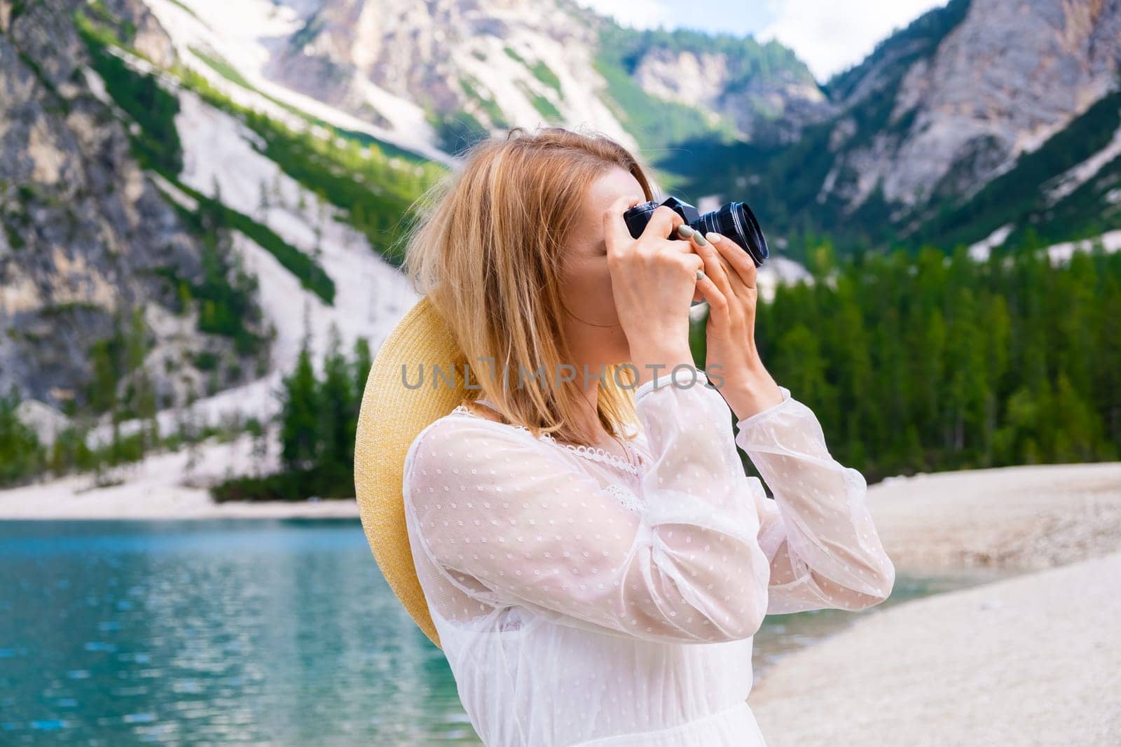 Attractive young woman taking photos of mountains and lake by vladimka
