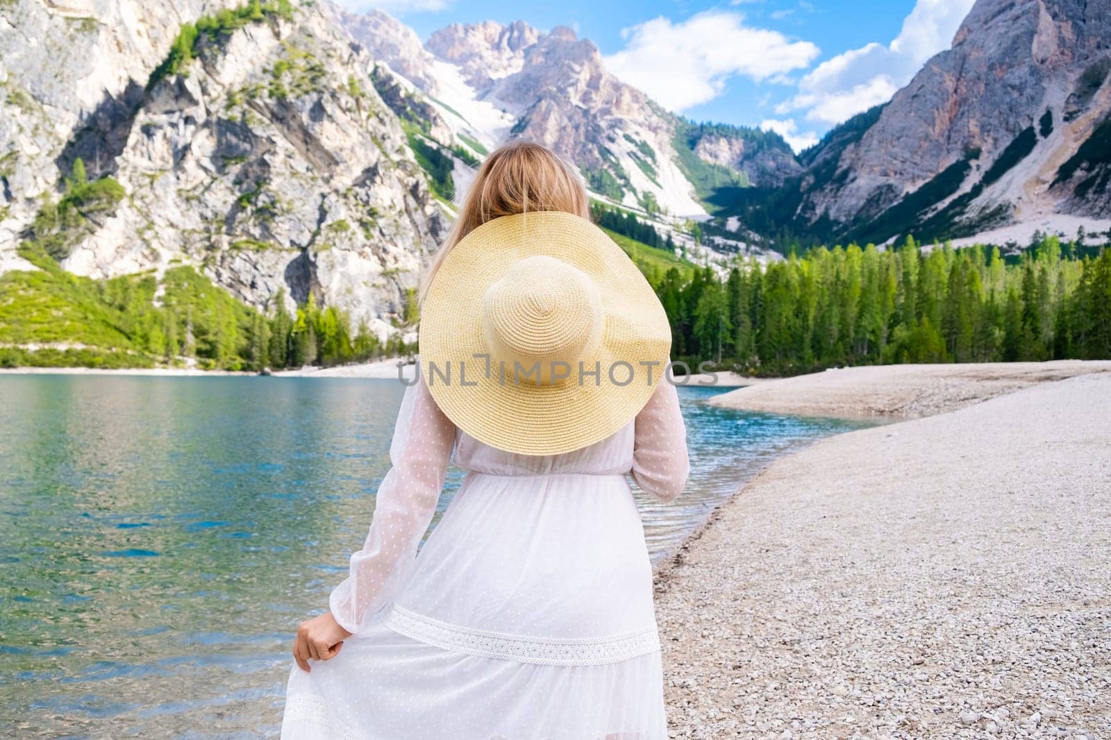 Young girl enjoying the beauty of nature looking at mountains and Lake Braies.