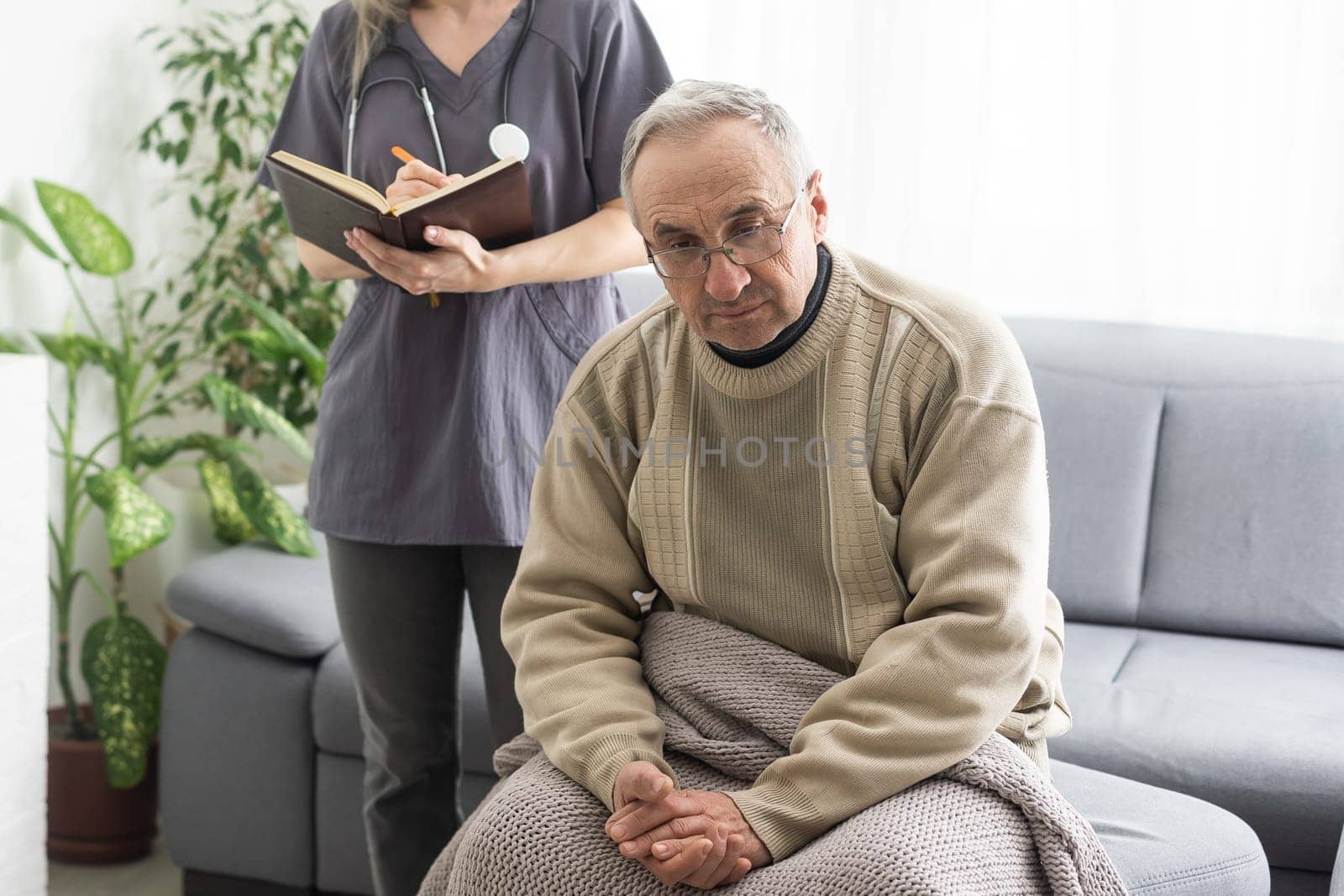 Kind female doctor embracing encouraging senior male patient in hospital. Happy healthy older man and his physician enjoying talking at nursing home. Elderly medical health care concept