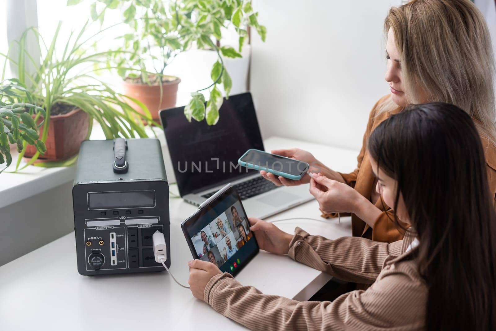 mother and daughter use portable charger.