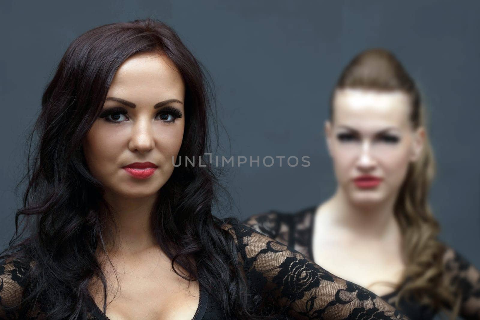 Portrait of attractive curly brunette posing in studio, close-up