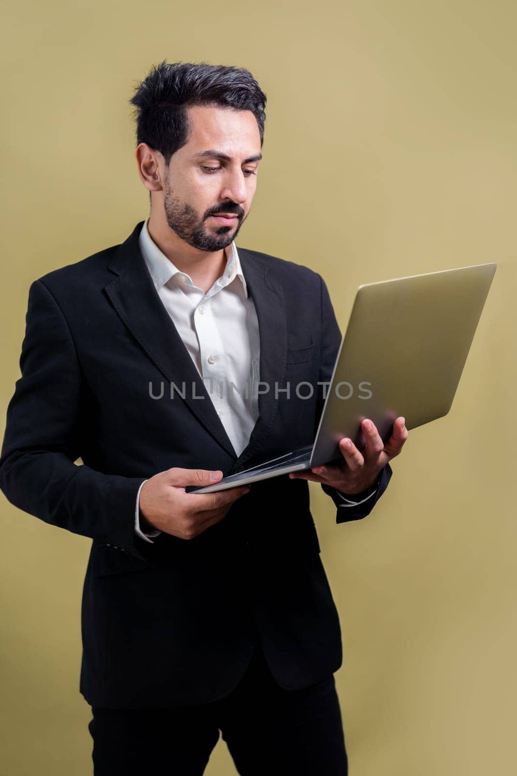 Successful businessman in black suit holding laptop. Fervent by biancoblue