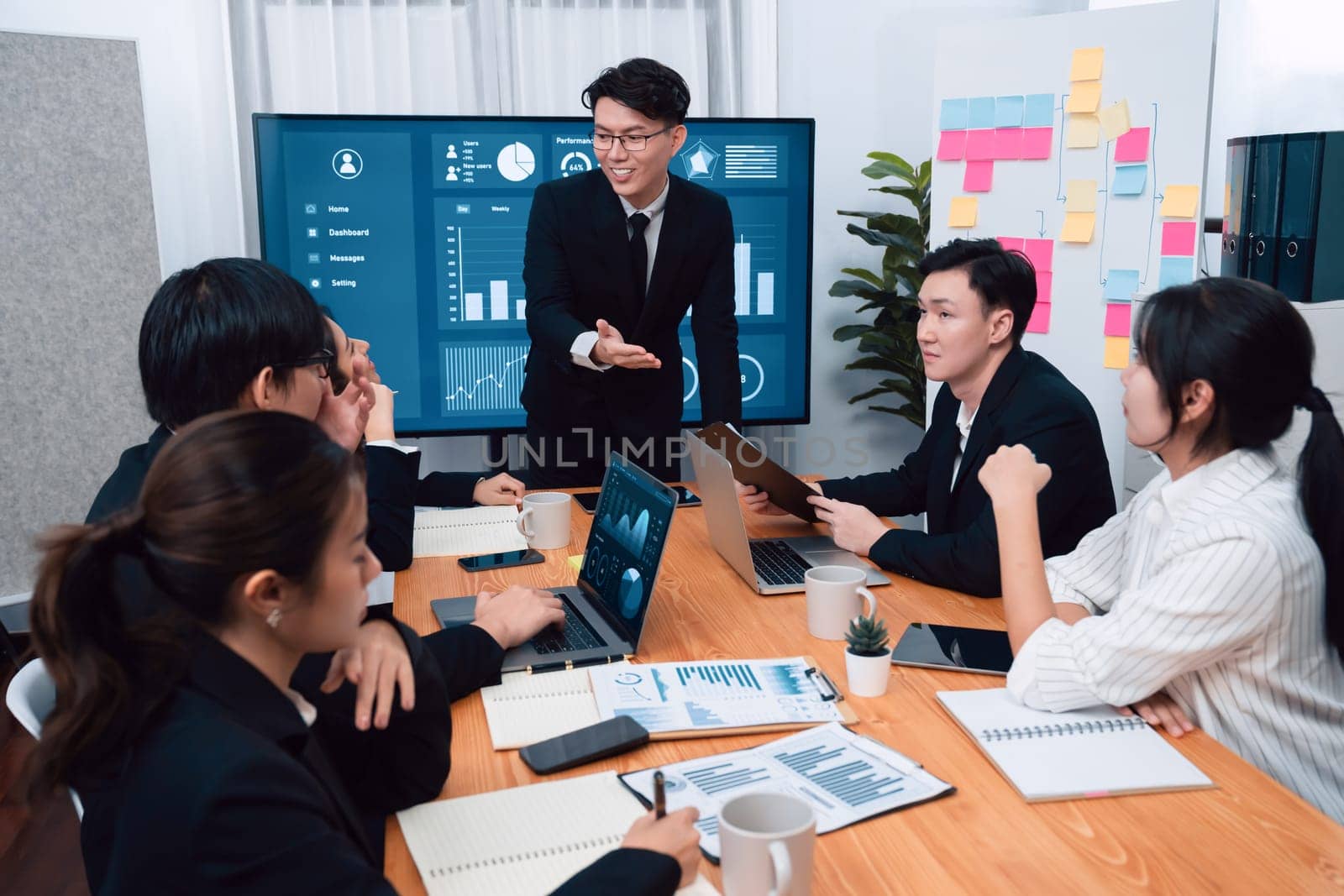 Confidence and asian businessman give presentation on financial analyzed by business intelligence in dashboard report to other people in board room meeting to promote harmony in workplace.