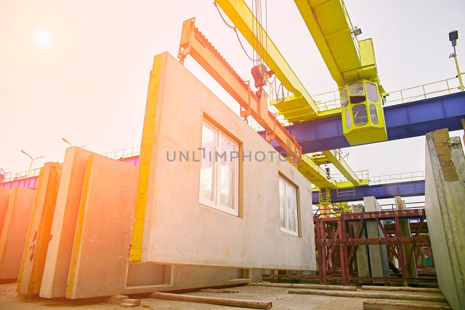 A builder installs a concrete floor slab panel at a construction site. Installation of a concrete floor slab for a multi-storey building.