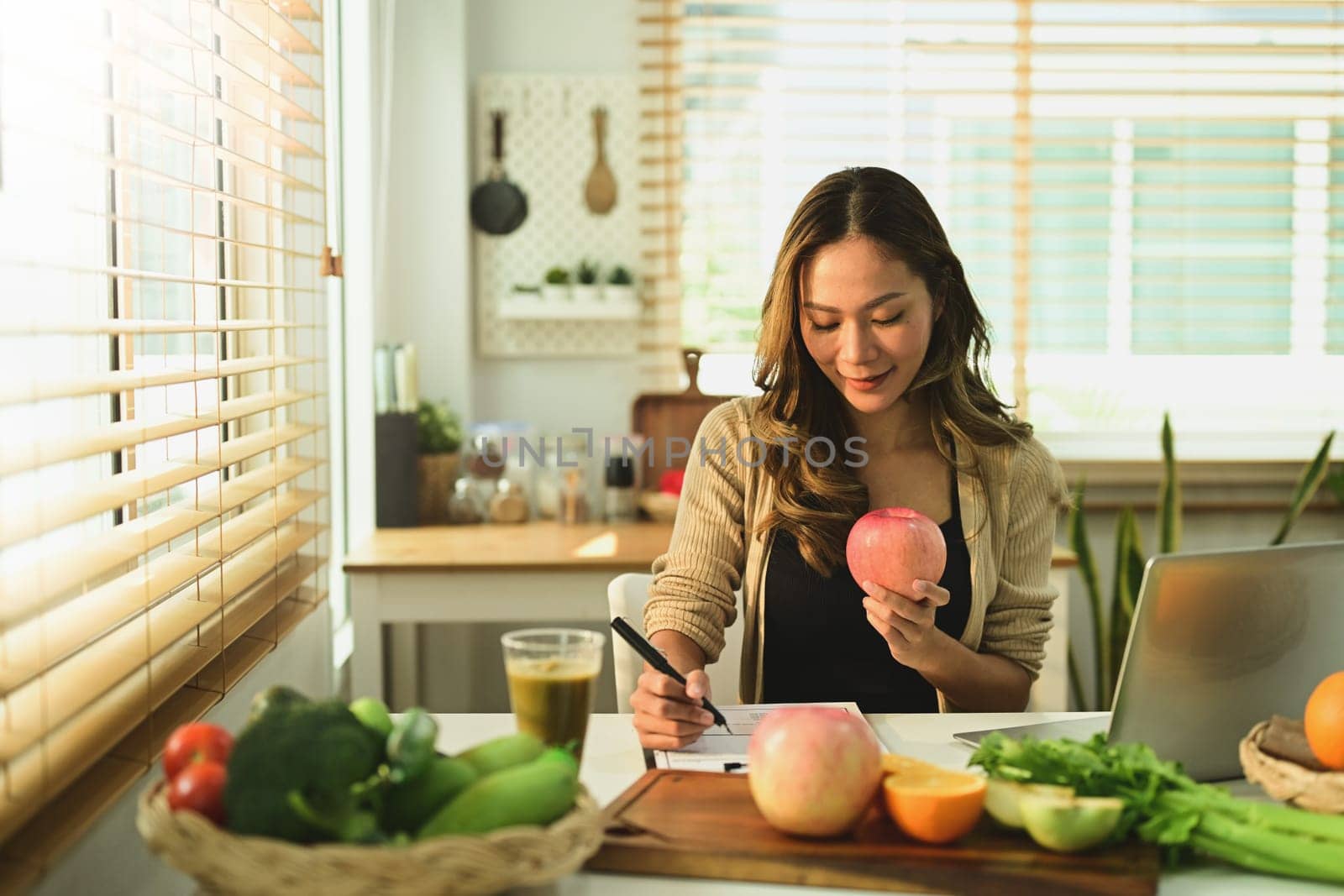 Nutritionist woman woking with fruits at her desk. by prathanchorruangsak