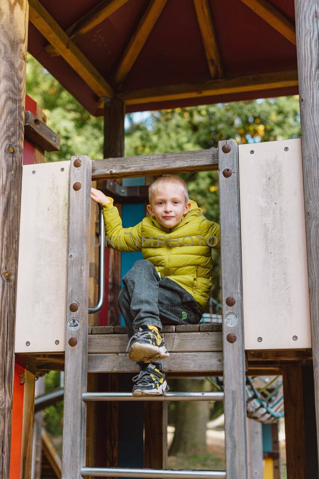 Boy At The Climbing Wall Without A Helmet, Danger At The Climbing Wall. Little Boy Climbing A Rock Wall Indoor by Andrii_Ko