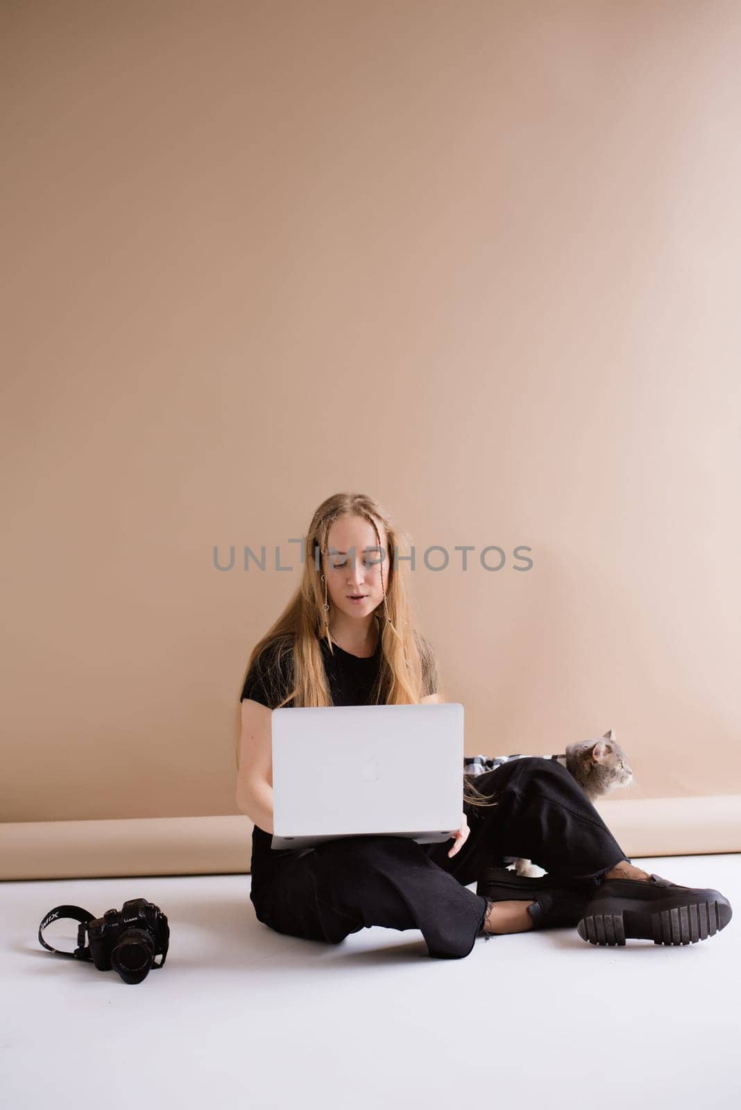 Woman freelancer typing to MacBook in photo studio by OksanaFedorchuk