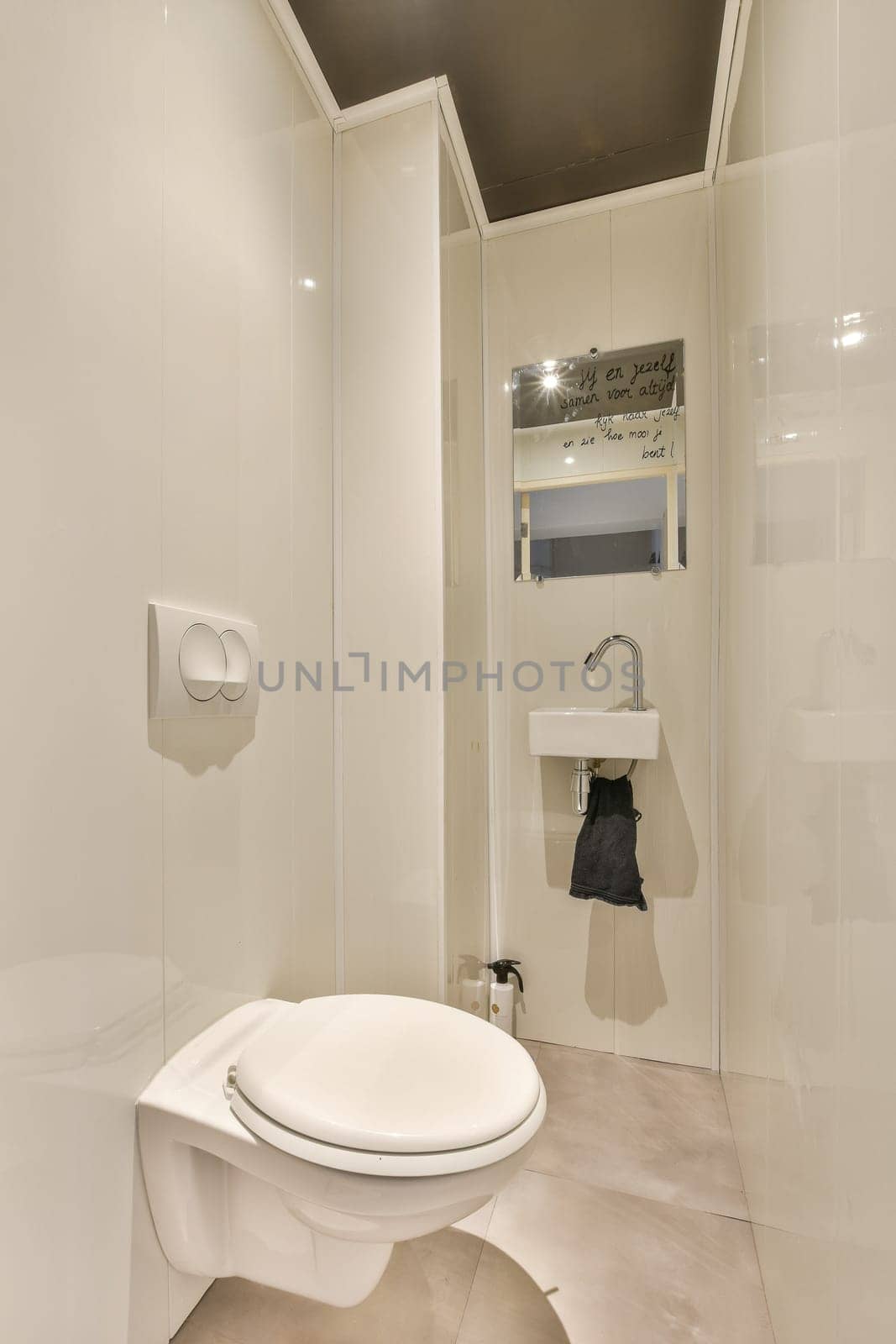 a white bathroom with a toilet and mirror in the shower stall, it appears to be used as a public restroom