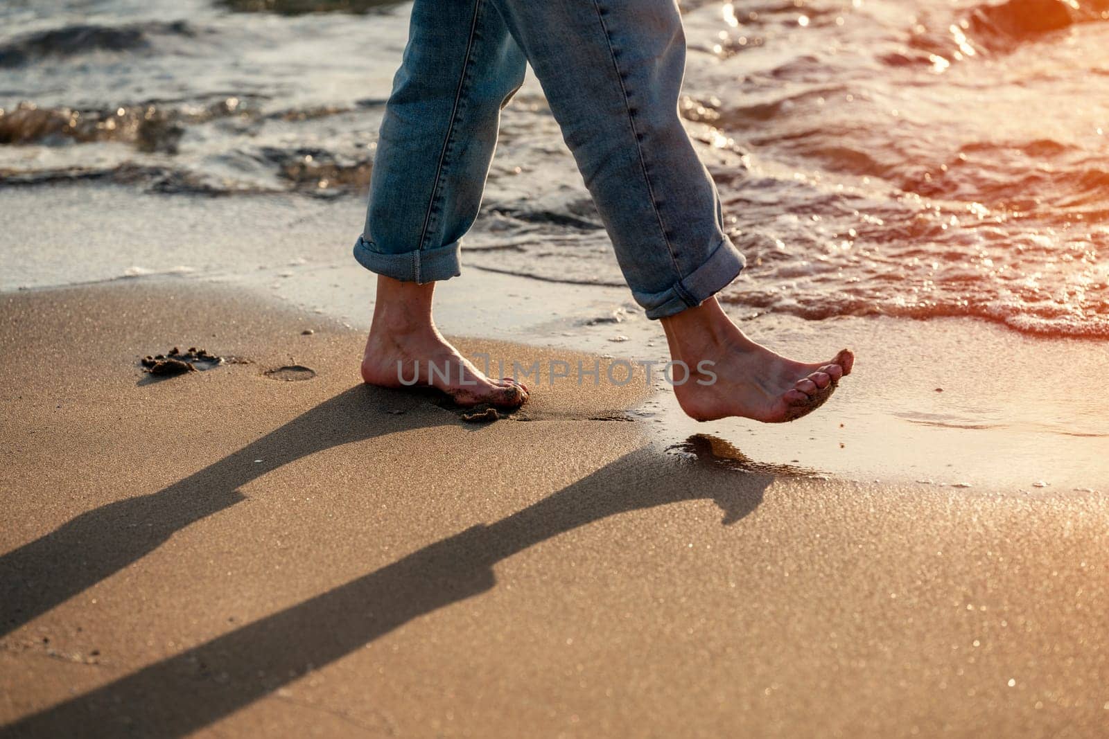 Close up of woman feet walking barefoot on seaside . Vacation, travel and freedom concept. People relaxing in summer. by Iryna_Melnyk