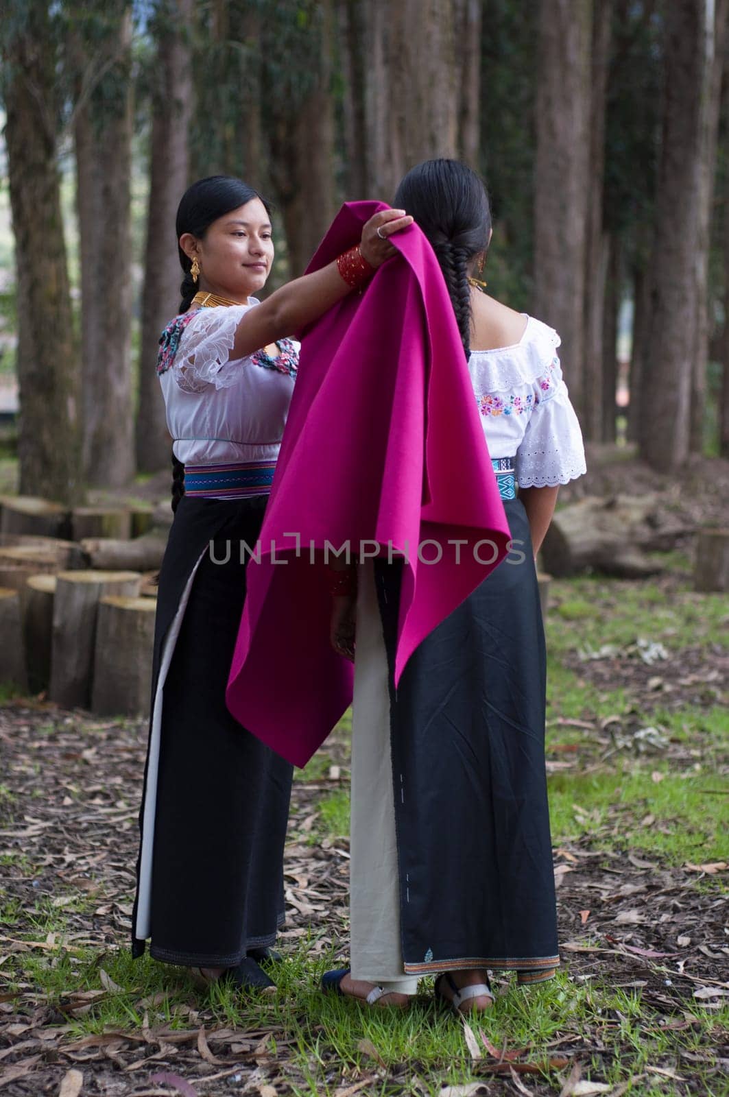 an indigenous girl tucking in a small indigenous girl in the forest of otavalo, ecuador. High quality photo