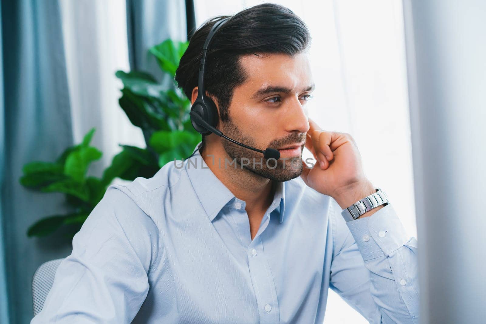 Male call center operator or telesales agent working on his desk. fervent by biancoblue
