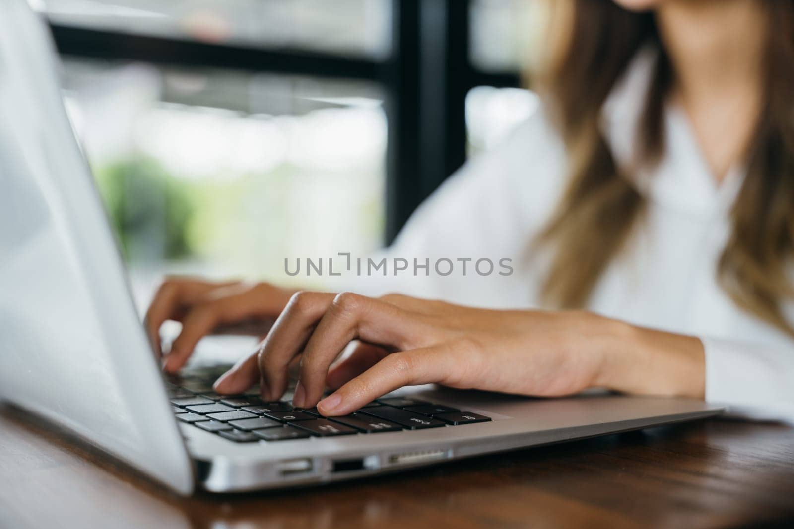 Happy beautiful freelancer typing keyboard on laptop, working online work outside office, Asian young businesswoman lifestyle sitting using laptop computer at cafe coffee shop