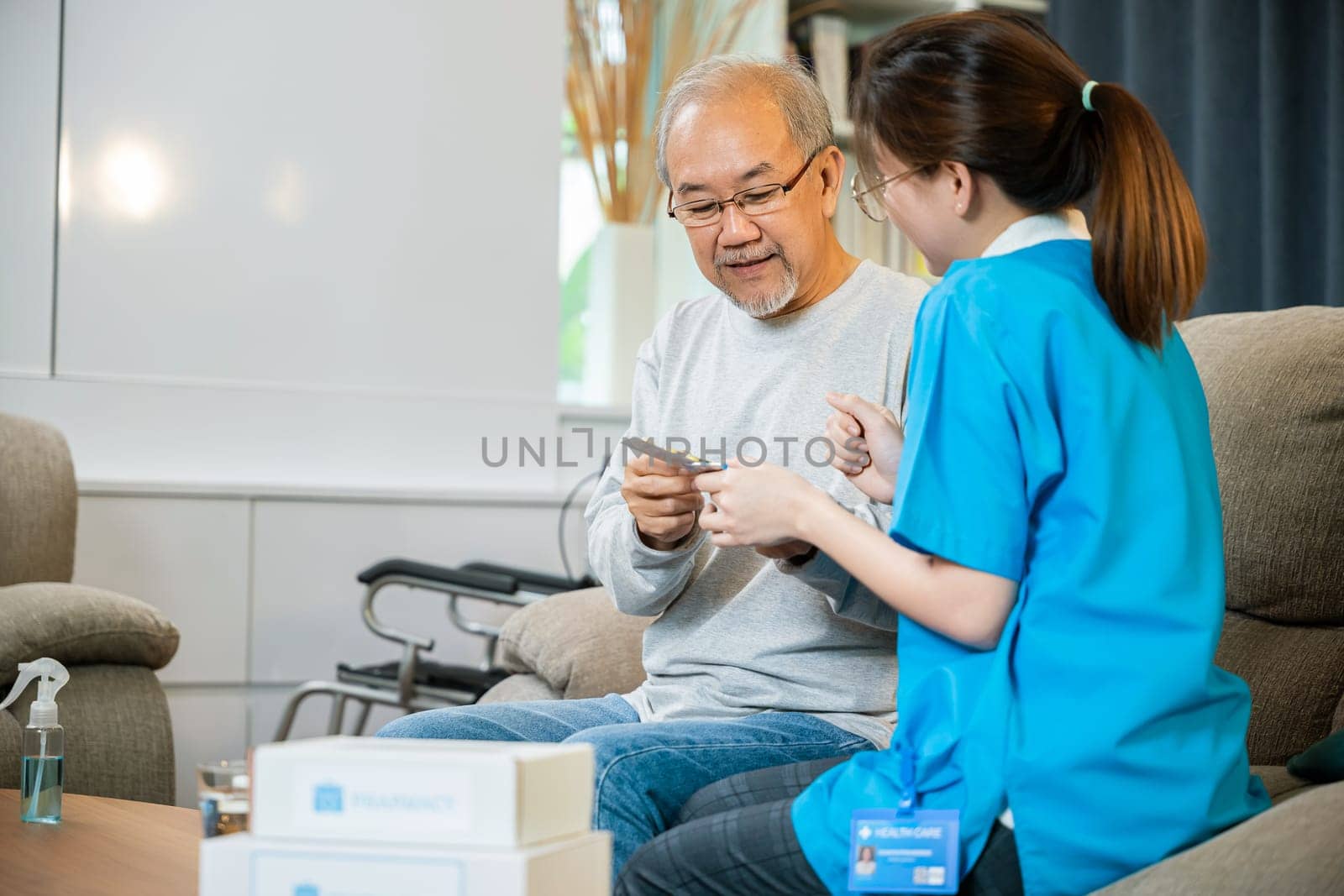 Woman nurse caregiver showing prescription drug to senior man at nursing home by Sorapop